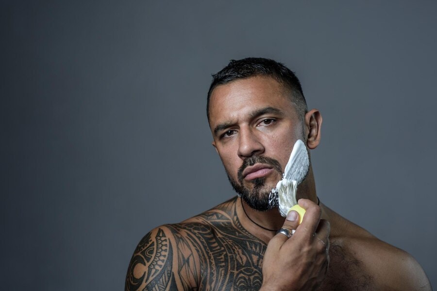 When Can You Shave Over a Tattoo? 1 Man with shoulder and chest tattoo shaving. When Can You Shave Over a Tattoo?