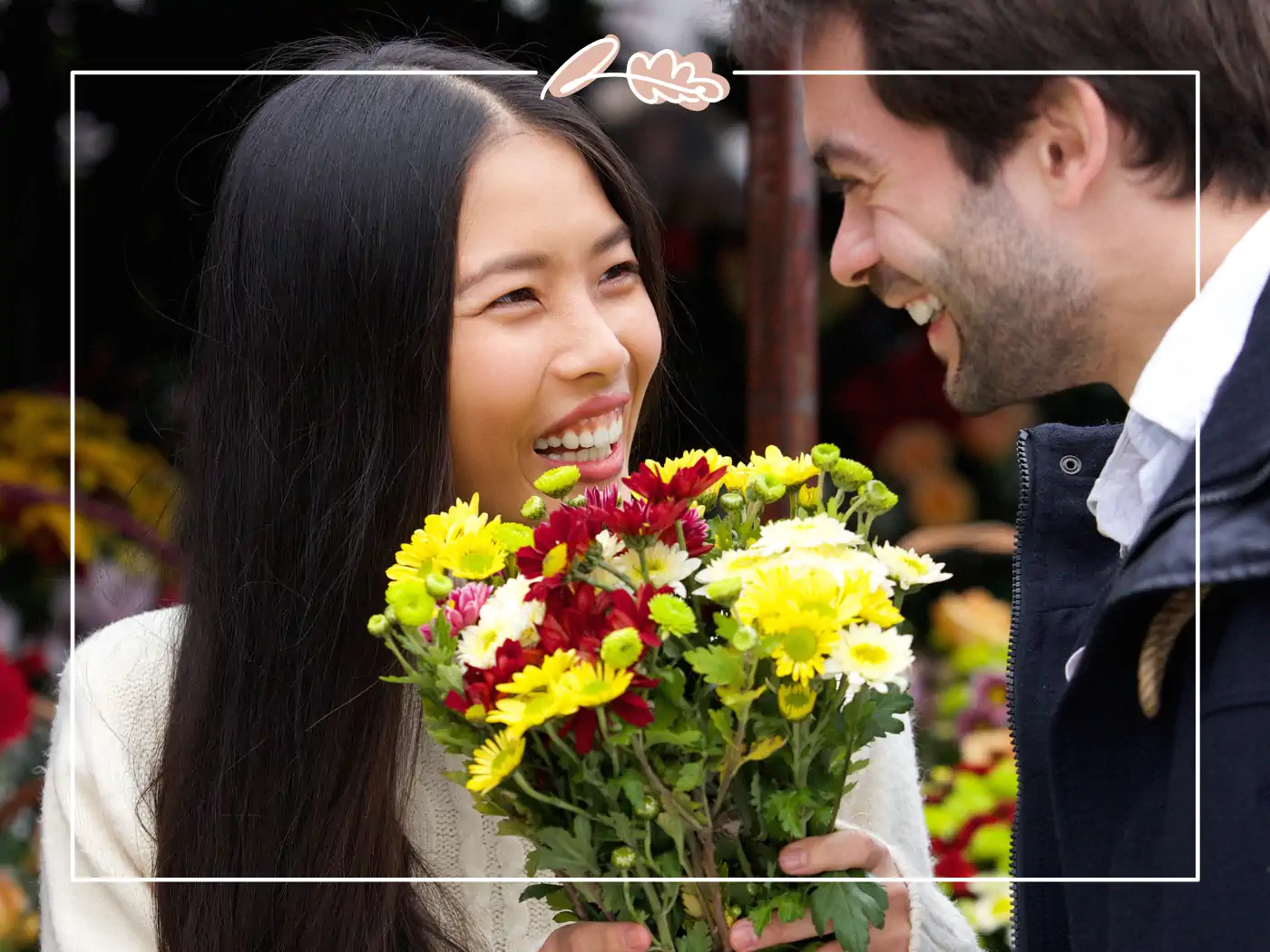 Smiling couple with a woman holding a bouquet of yellow and red flowers - Fabulous Flowers and gifts