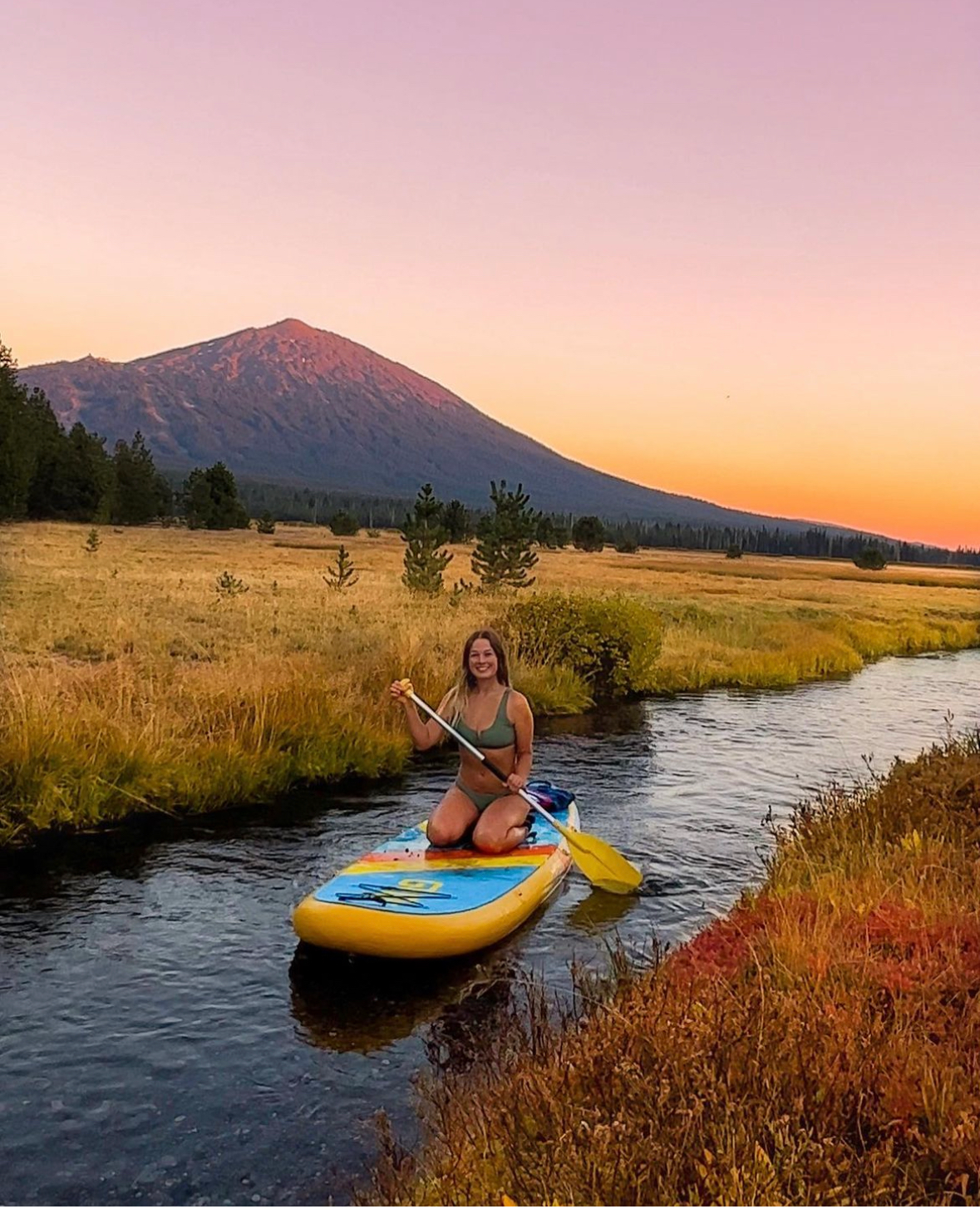 woman kneeling on an inflatable sup board