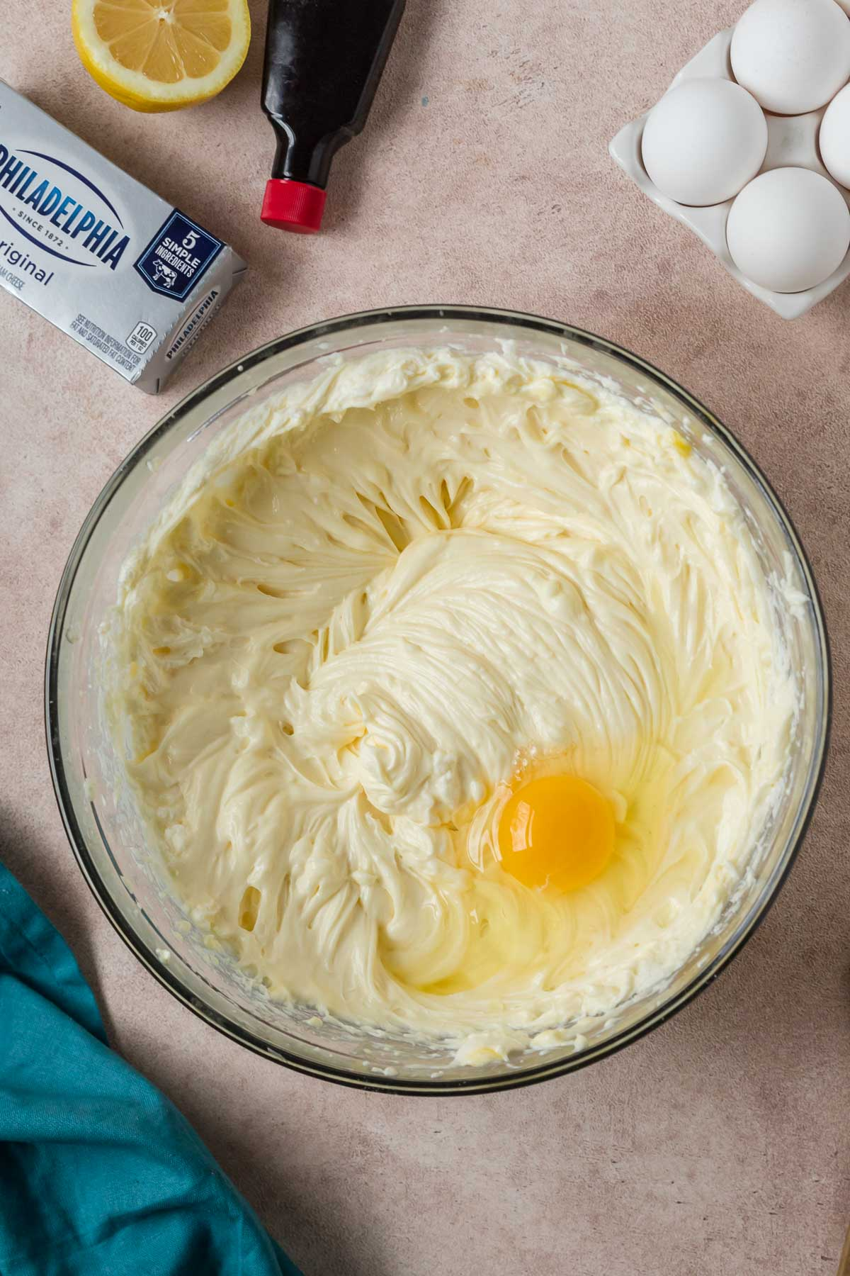 egg added to cheesecake mixture in bowl in bowl