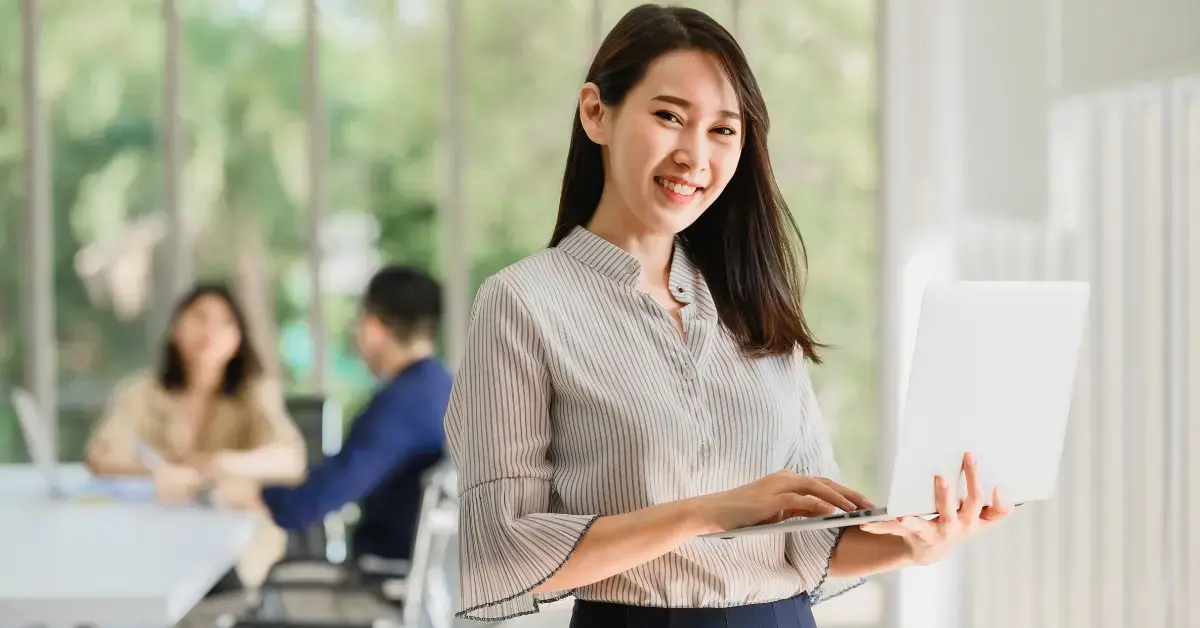 Woman holding a laptop offering a service on filing OnlyFans tax forms.