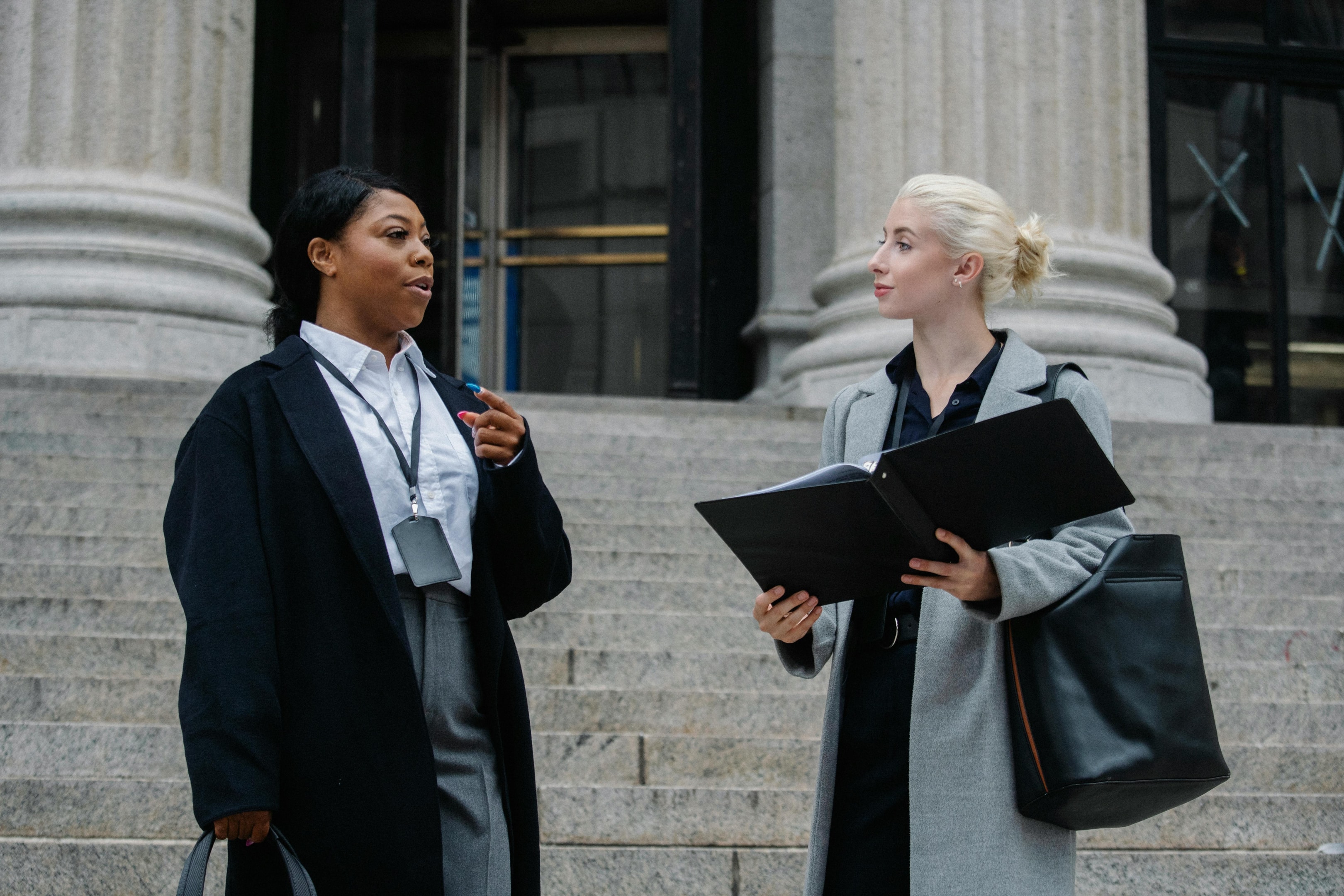 Two probate attorneys outside of courthouse discuss laws and regulations.