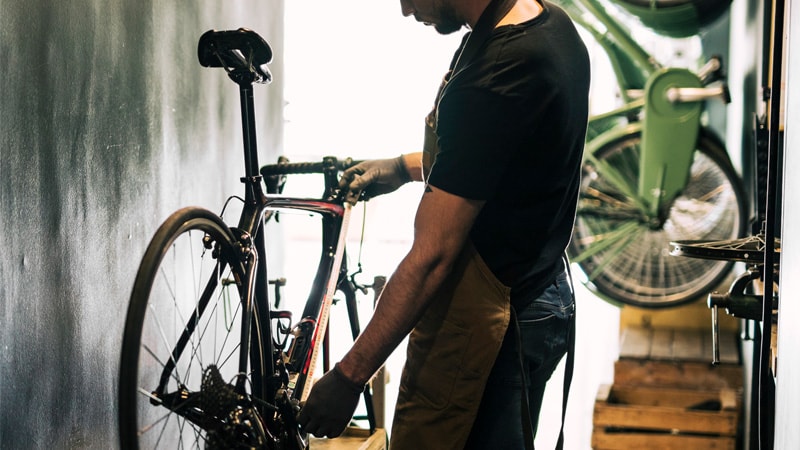 a cyclist measuring the dimension of the bike frame