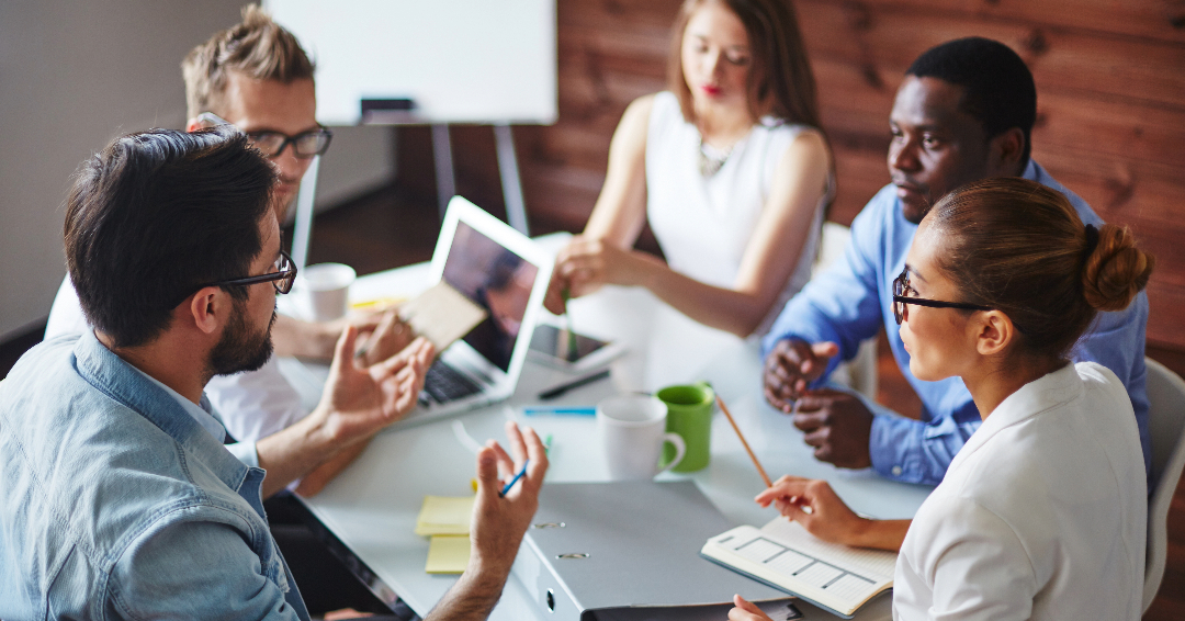 A group of executives discussing the role of psychology in executive coaching