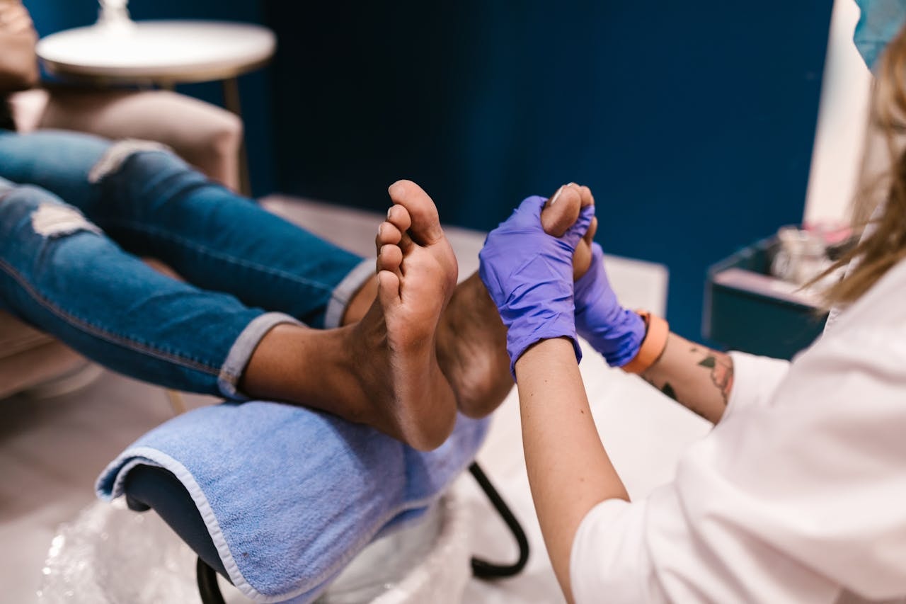 Foot specialist examining a patient’s big toe and forefoot during a clinic visit, explaining why is bunion surgery not recommended until pain and function problems persist.
