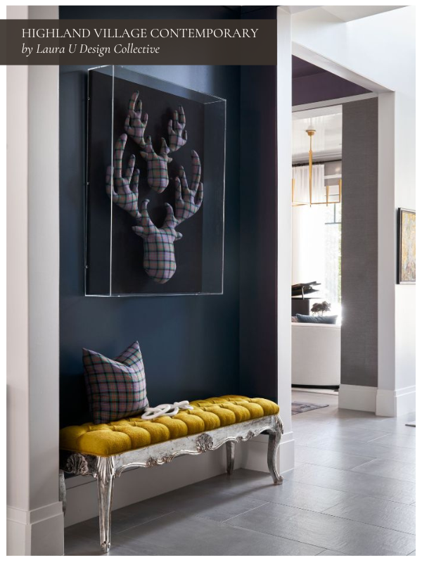 A navy-painted entry niche with a yellow tufted bench and plaid pillow. Above, a sculptural moose head art piece adds playful contrast to the polished contemporary space.