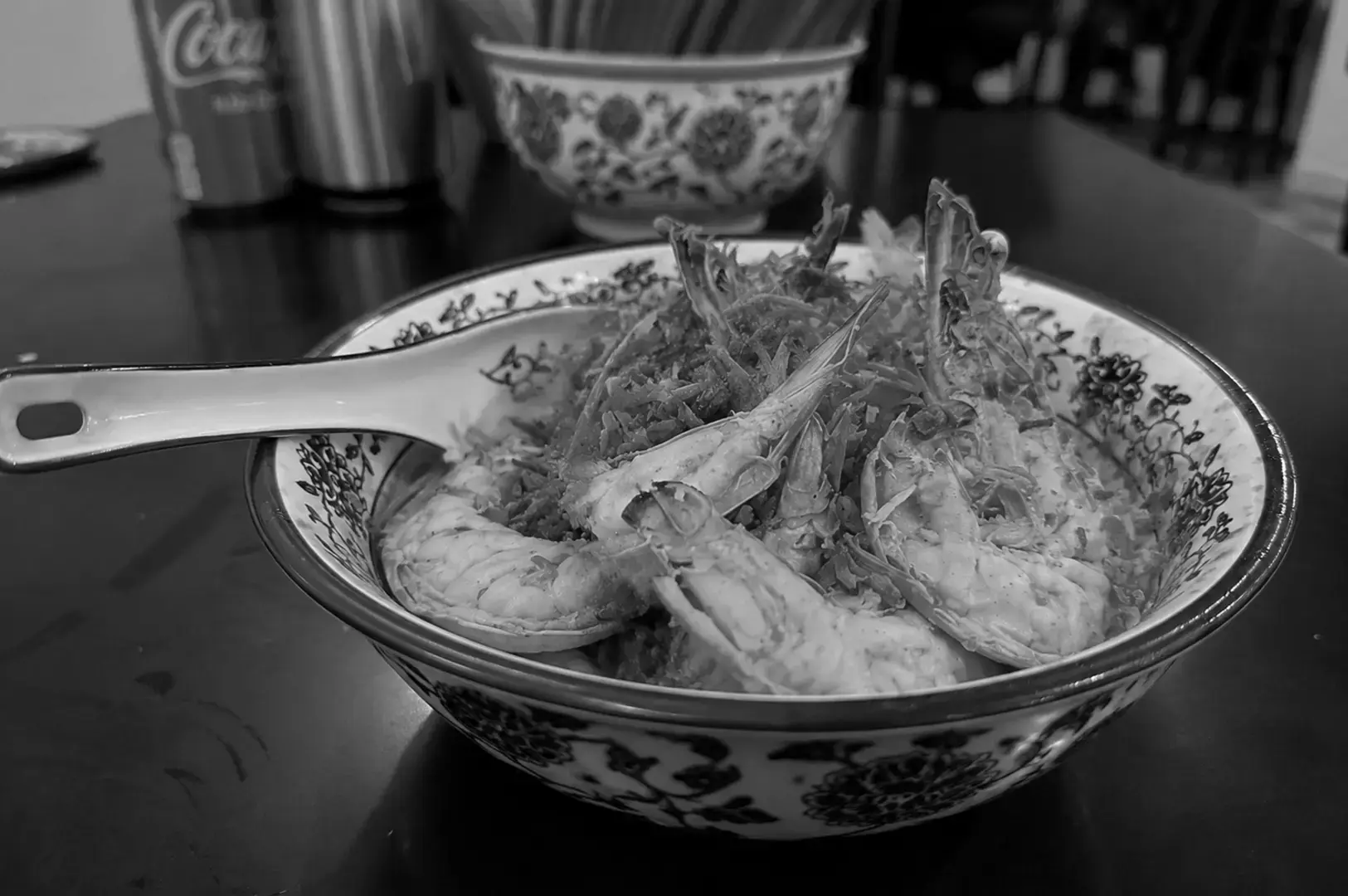 Bowl of dry prawn noodles topped with large prawns and crispy fried shallots.