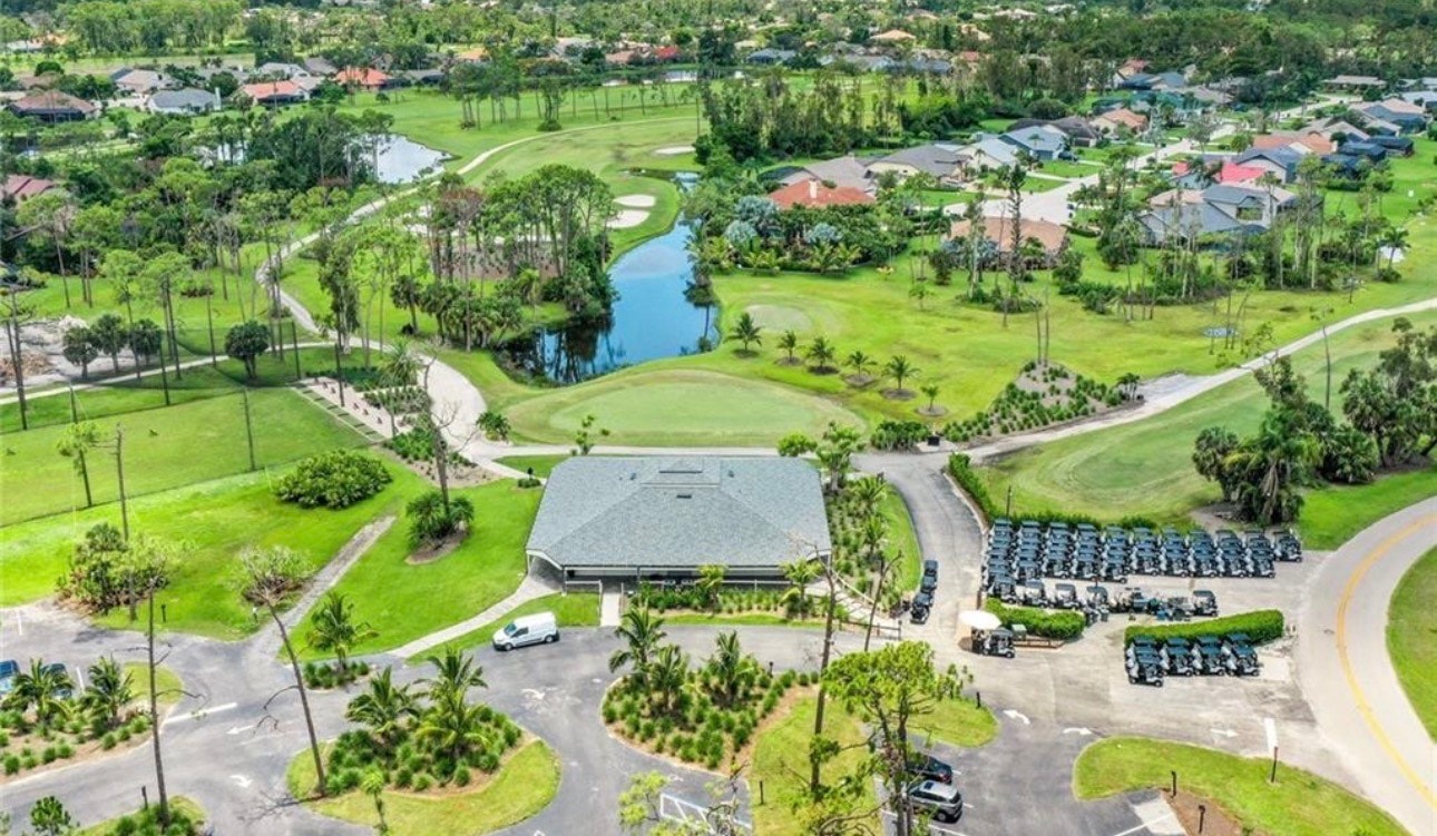 A scenic view of a golf course fairway at Eagle Ridge in Fort Myers, featuring strategically placed sand bunkers and water hazards, all framed by lush, mature trees. This picturesque landscape highlights the beauty of the community, perfect for those searching for Eagle Ridge homes for sale.