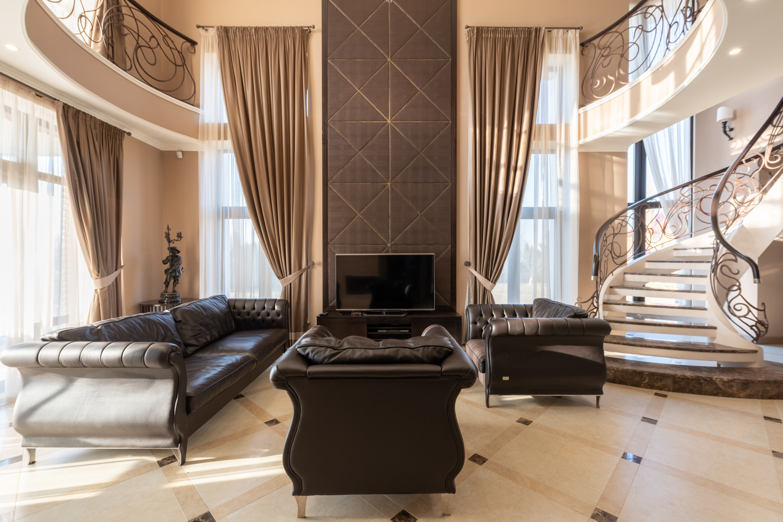 luxurious leather sofas in large room with staircase