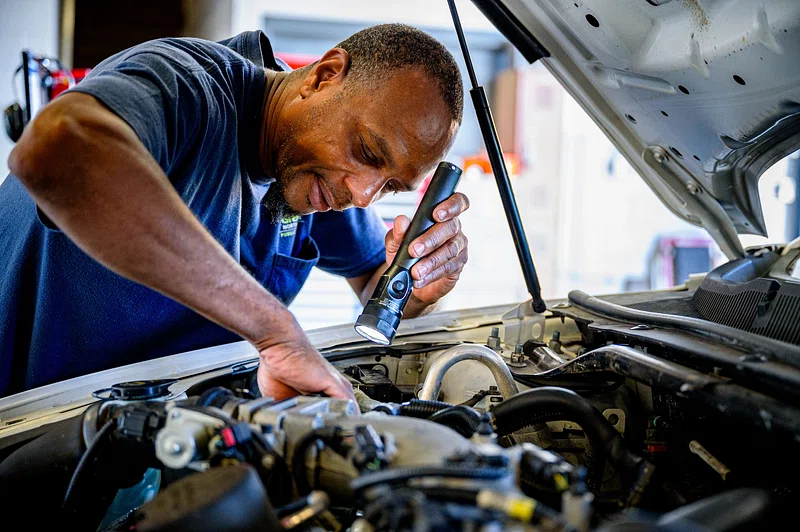 A mechanic inspecting a transmission in a repair shop