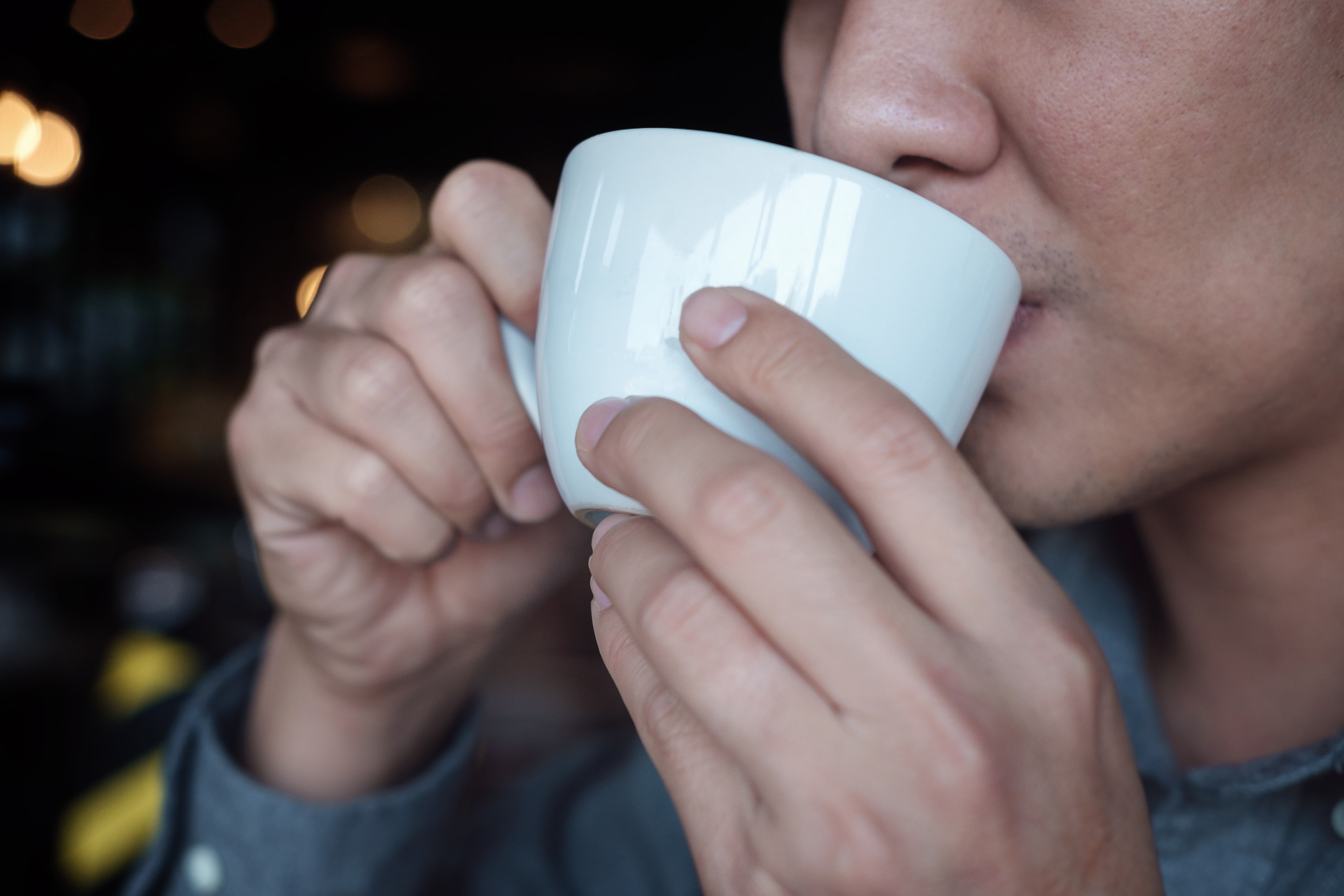 Man enjoying espresso from a white cup