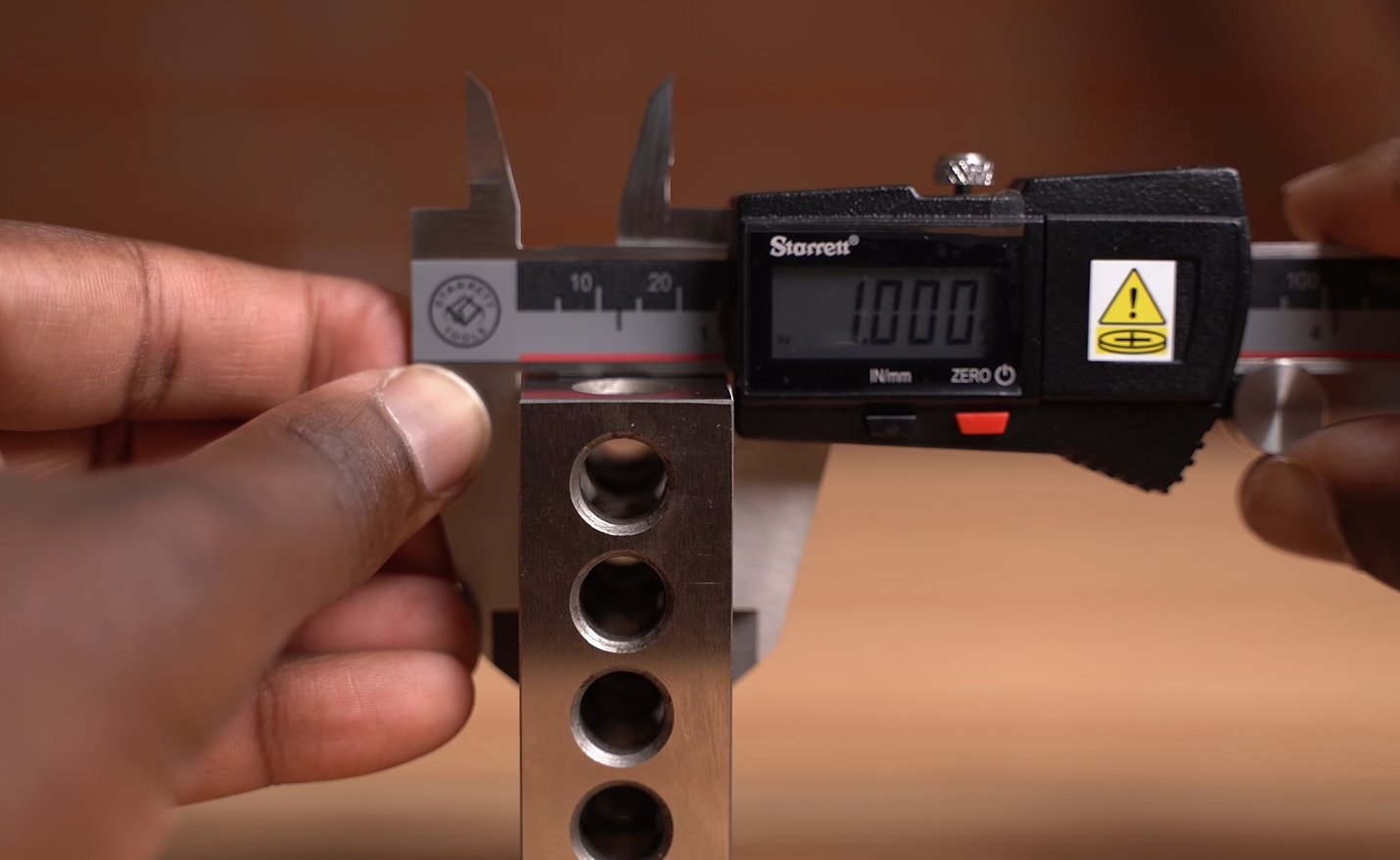 using Starrett caliper to measure the outside of a 1 inch block