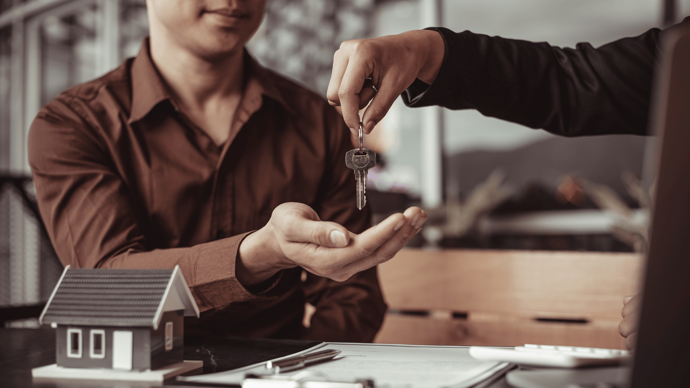 Landlord giving keys to a tenant, symbolizing lease agreements and rent control policies.