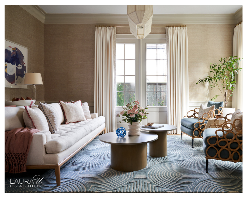 Formal sitting room featuring Phillip Jeffries Saint Germain Hemp II Gold on White grasscloth wallpaper with a cream Lawson Fenning sofa, blue accent chairs, sculptural coffee tables, brass accents, and contemporary artwork.