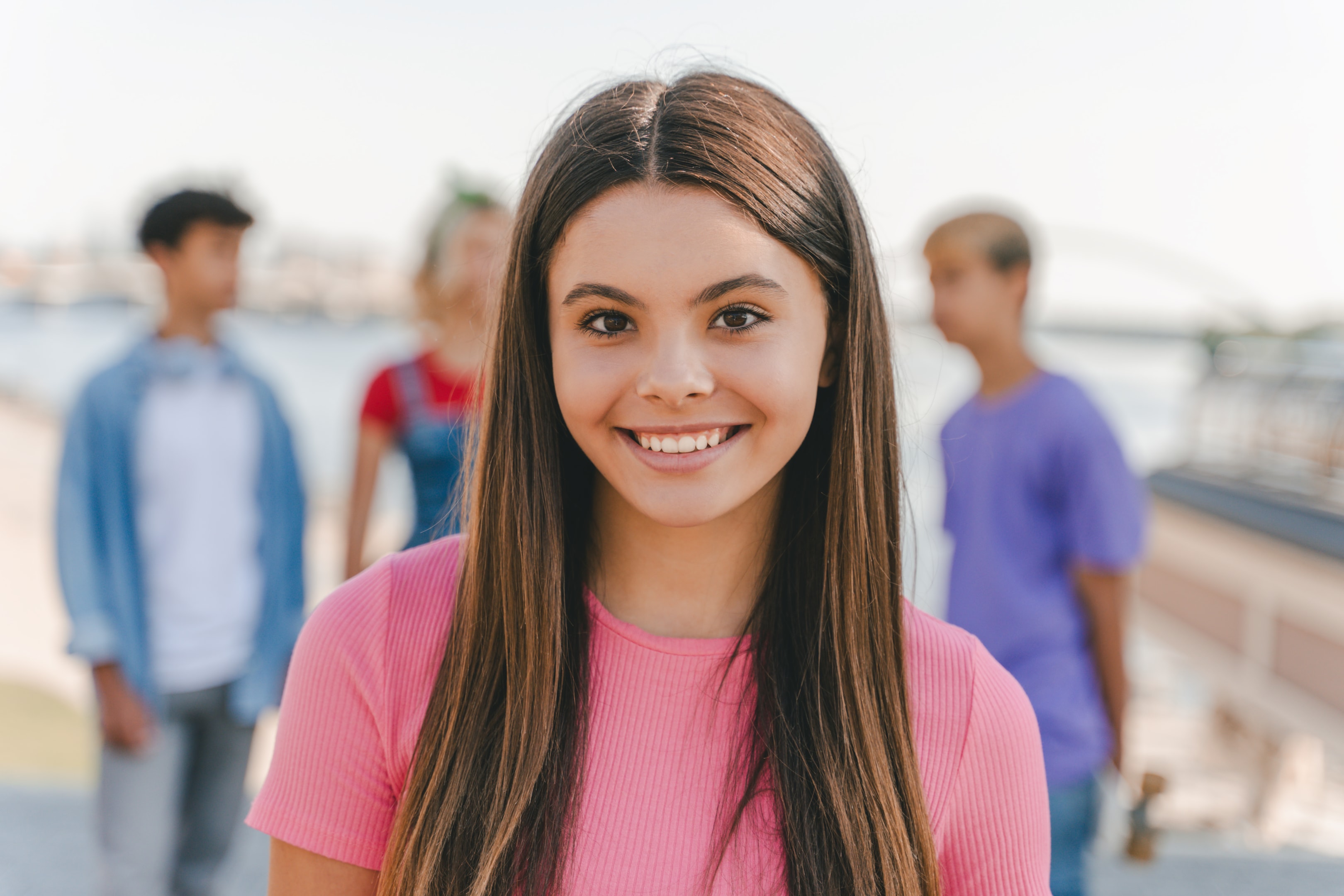 a smiling girl who has dental implants to completely replace severely damaged teeth