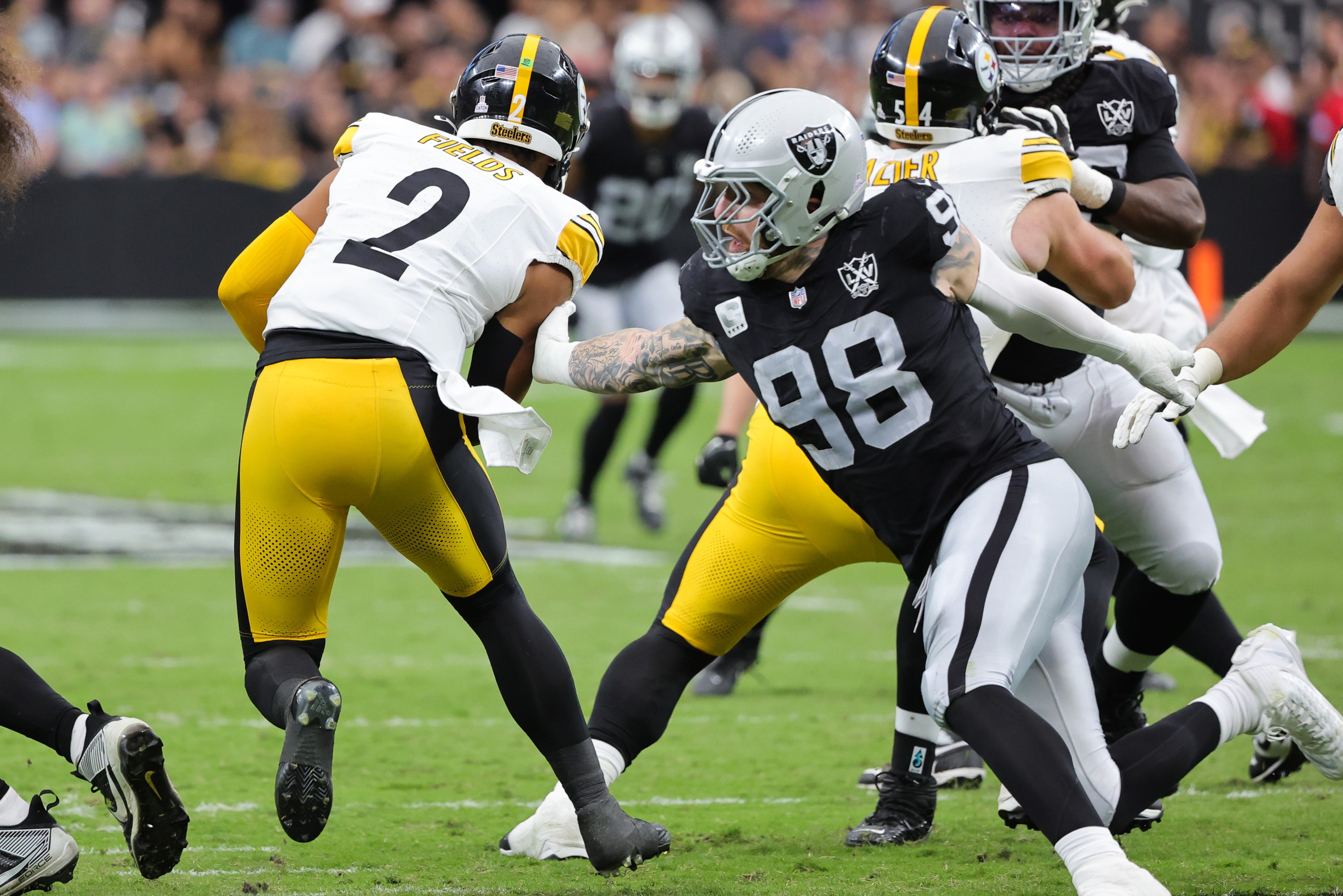 Maxx Crosby of the Las Vegas Raiders tries to sack Justin Fields of the Pittsburgh Steelers in a game at Allegiant Stadium on October 13, 2024 in Las Vegas, Nevada.