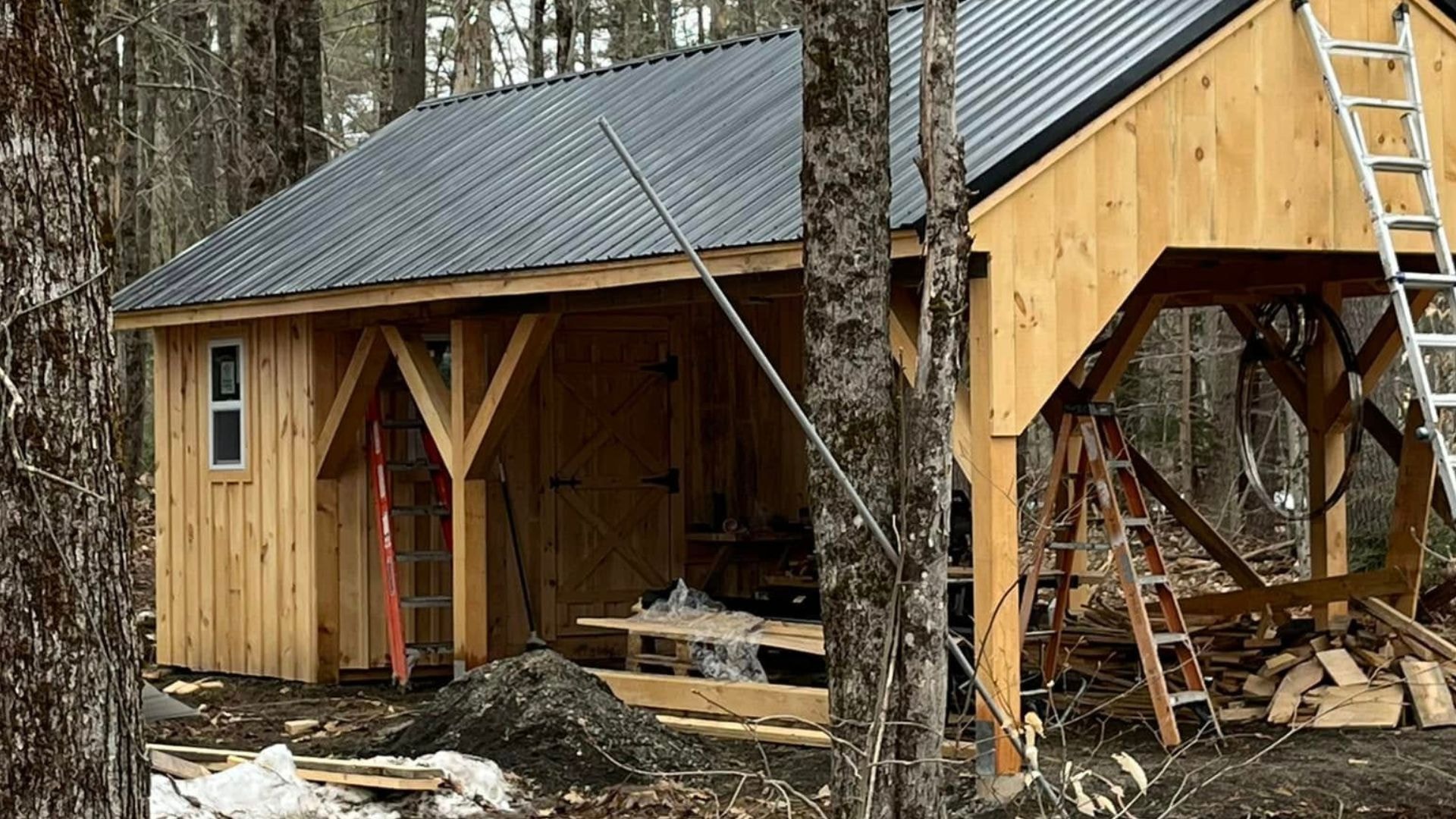 An awesome sawmill shed with exterior siding and exposed timber frame posts.