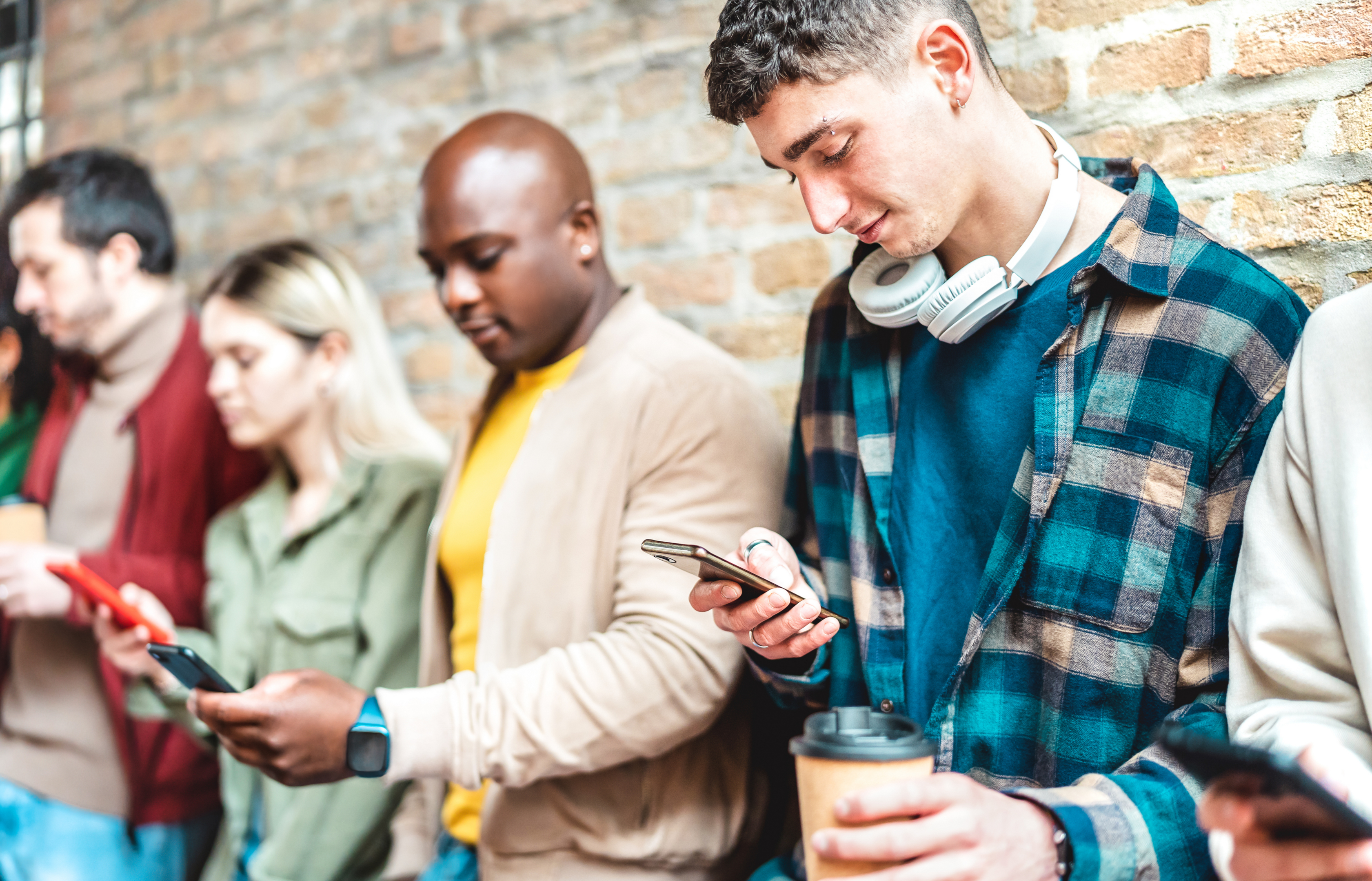 Group of different people all using their mobiles