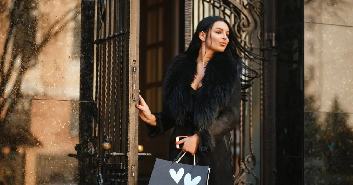 OnlyFans creator holding a luxury bag at the door, ready for a day of luxury tax planning and style.