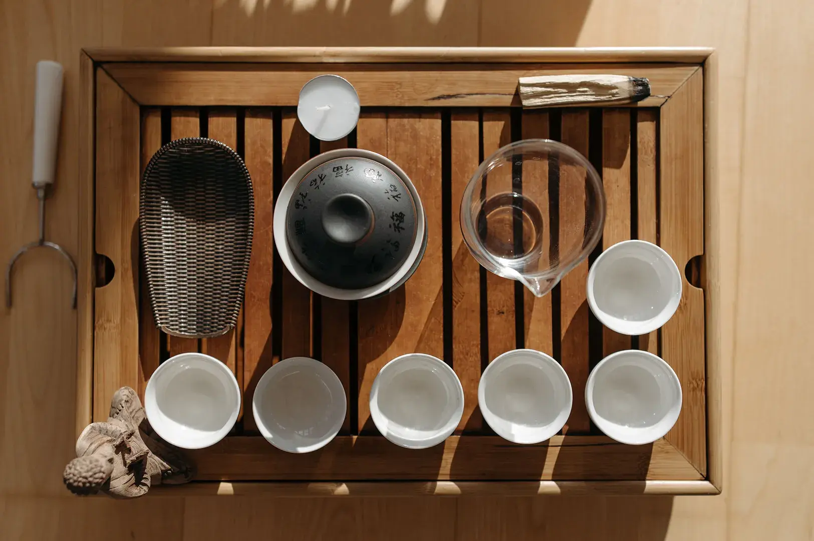 Traditional Gongfu tea set with gaiwan and cups on a slatted wooden tray.