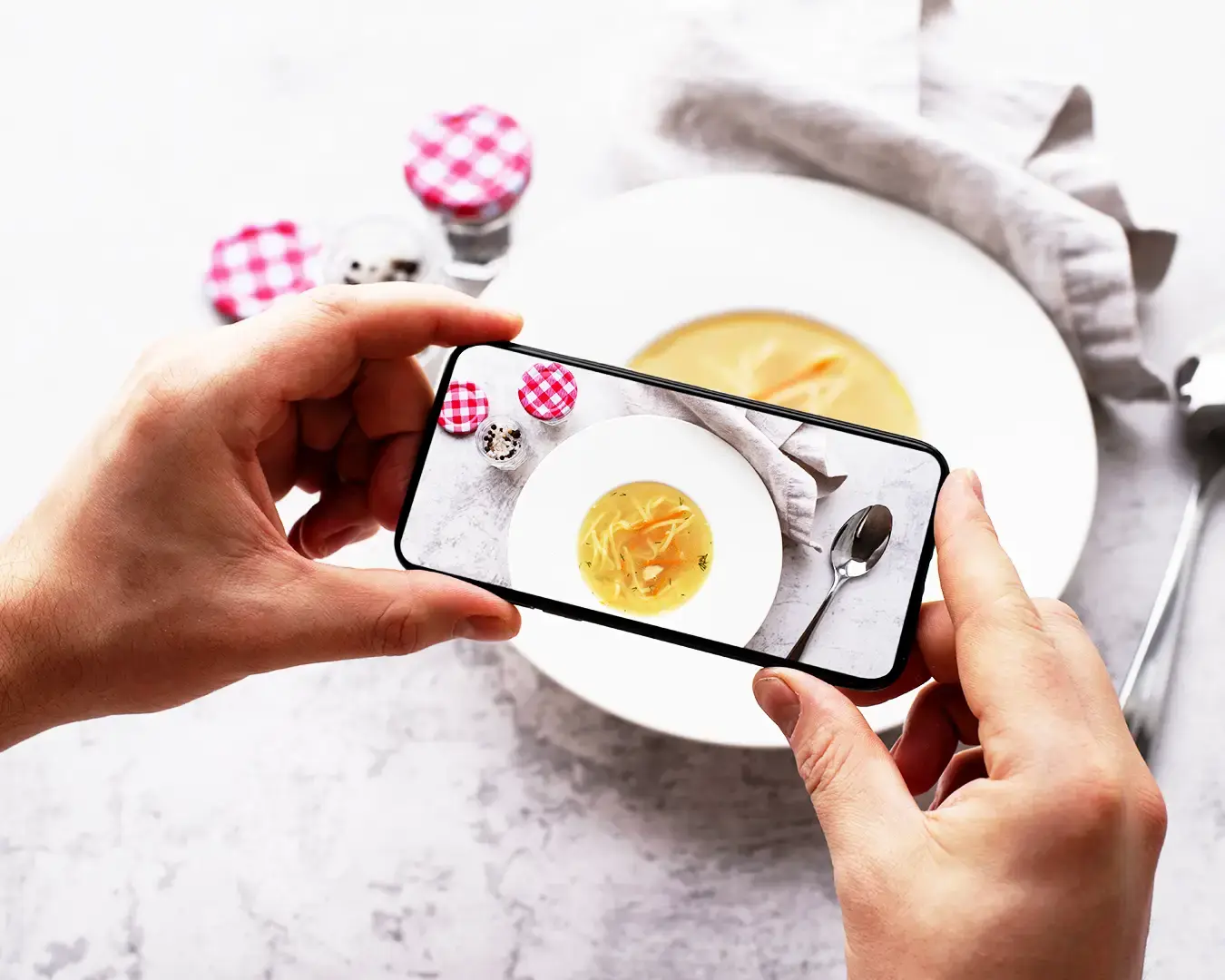 Restaurant customer photographing food with smartphone for social media marketing and F&B content creation
