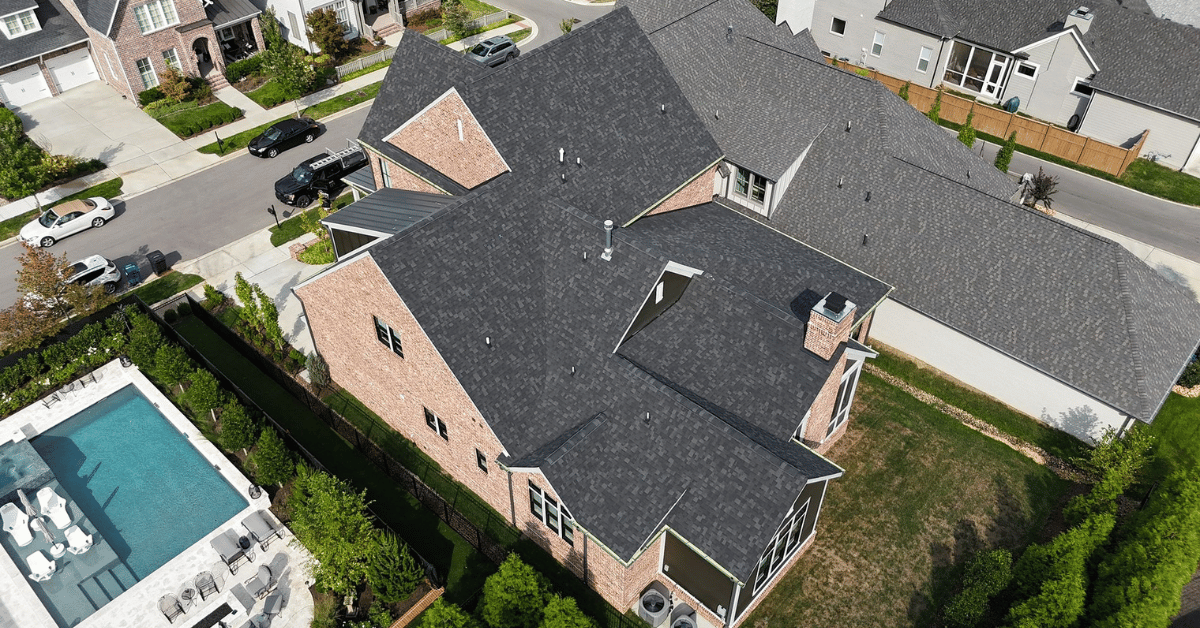 High-resolution aerial image of a newly completed roof replacement on a large brick home in Franklin, TN.