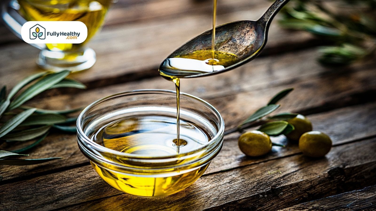 Spoon dripping golden olive oil into a small glass bowl