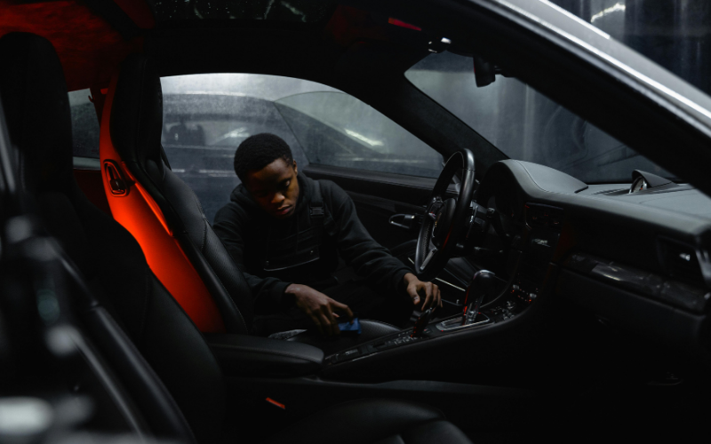 Person cleaning the car interior with detailing tools during a car wash