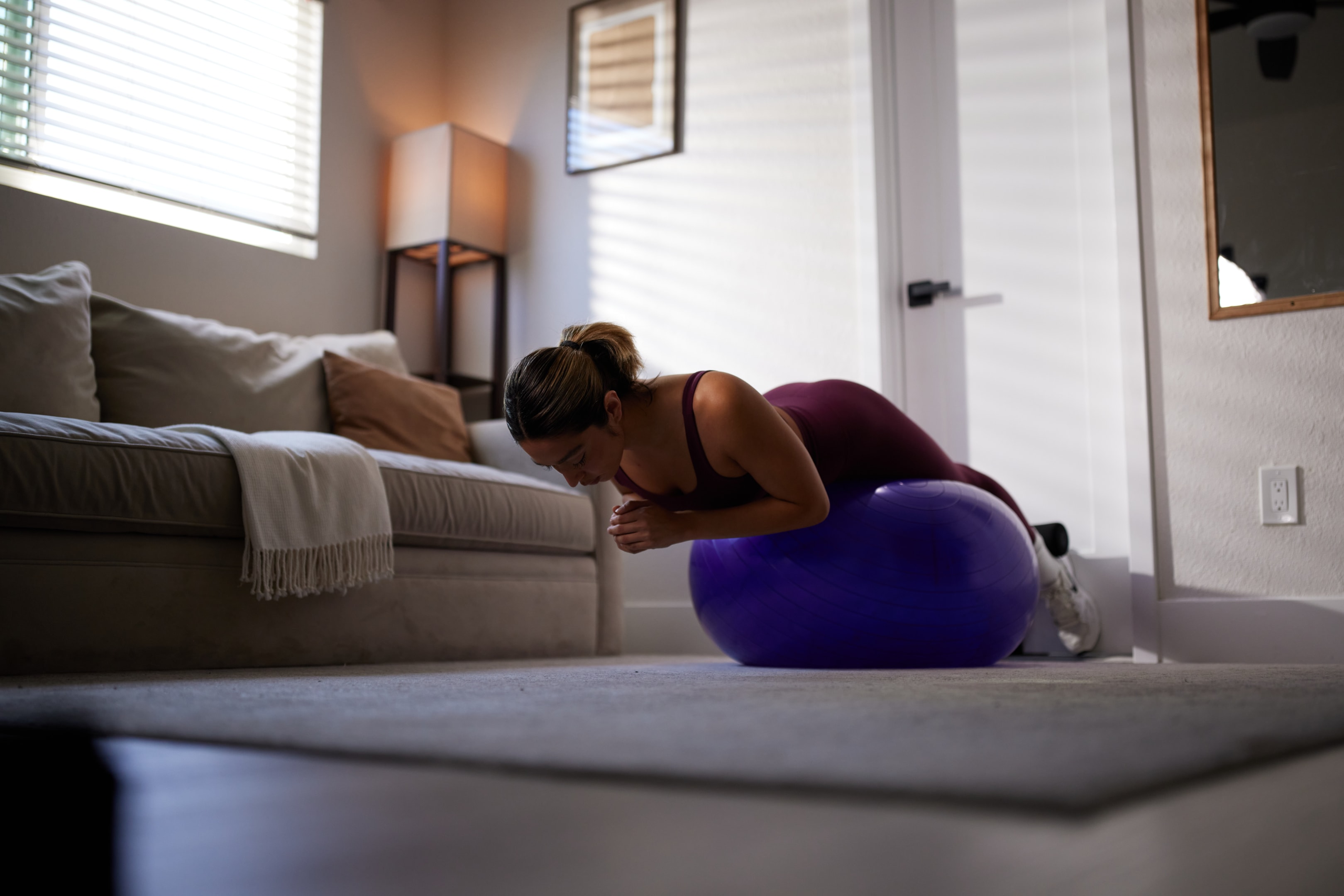 Back extensions with your legs extended and feet resting on a plank position while resting on a bouncy ball.