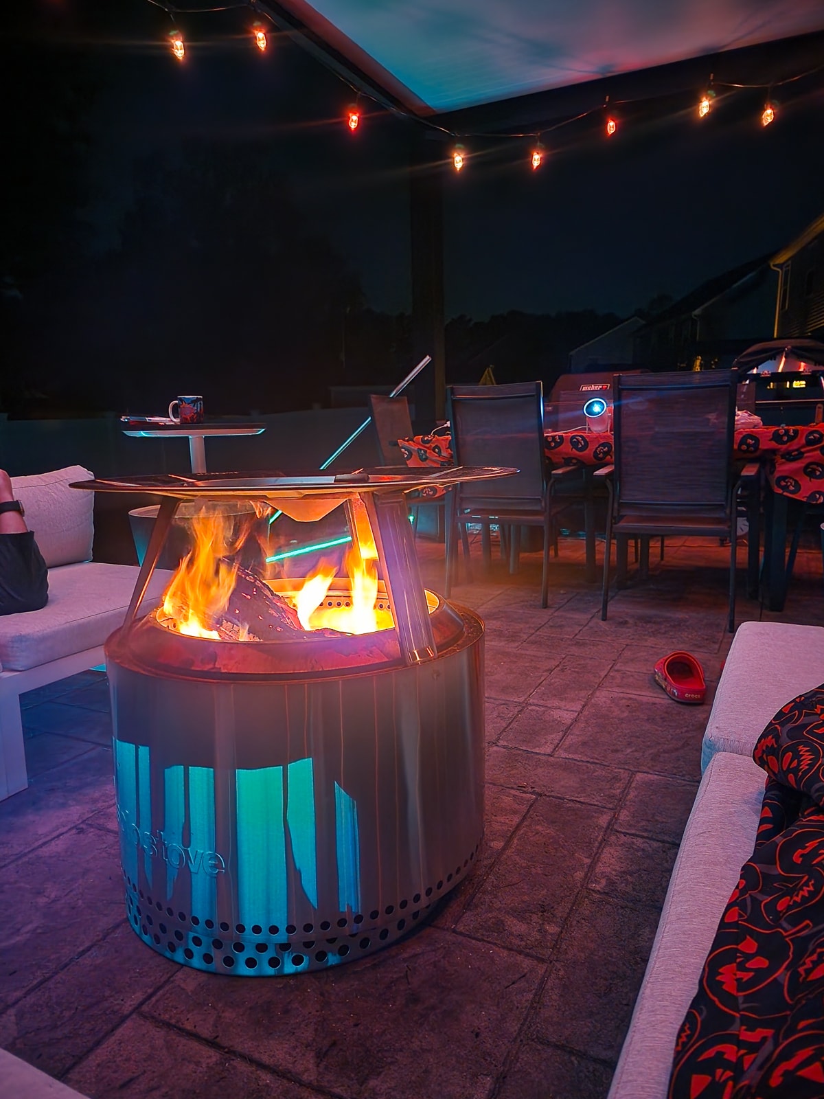 Small aluminum woodburning stove installed under a luxury pergola.
