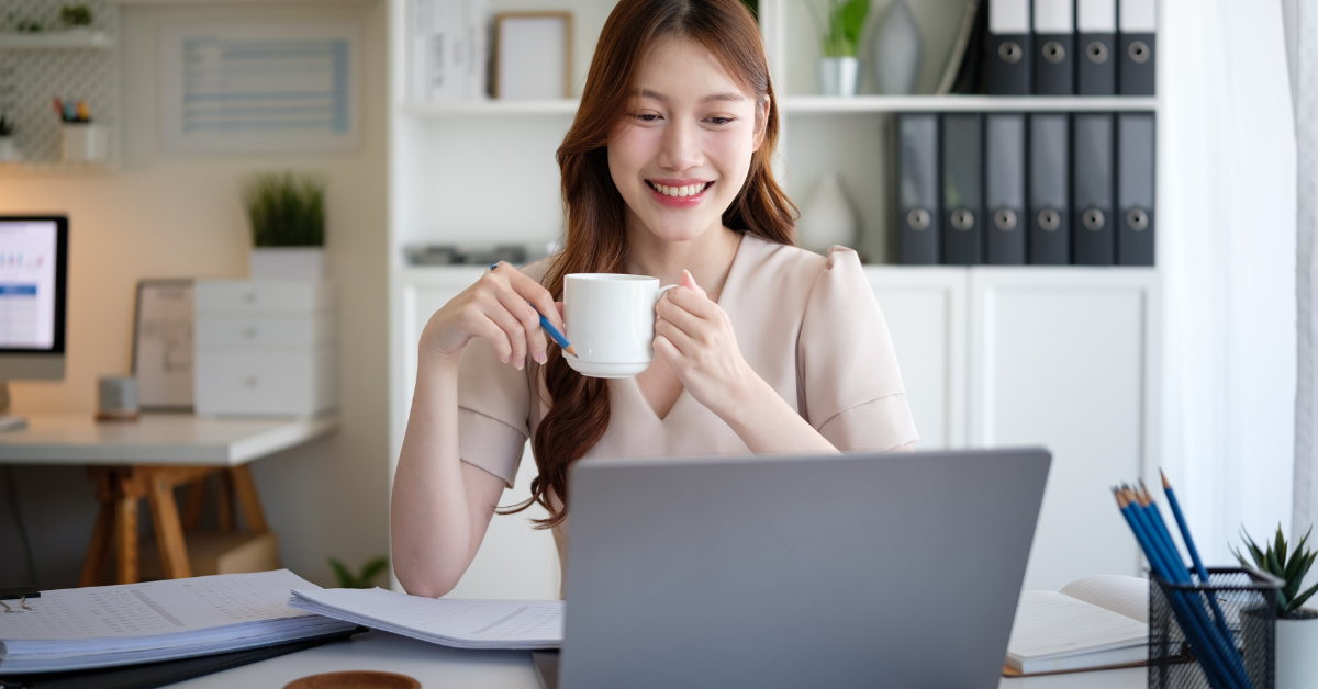 A woman preparing Form 1040 NR at home while reviewing her business income paperwork.