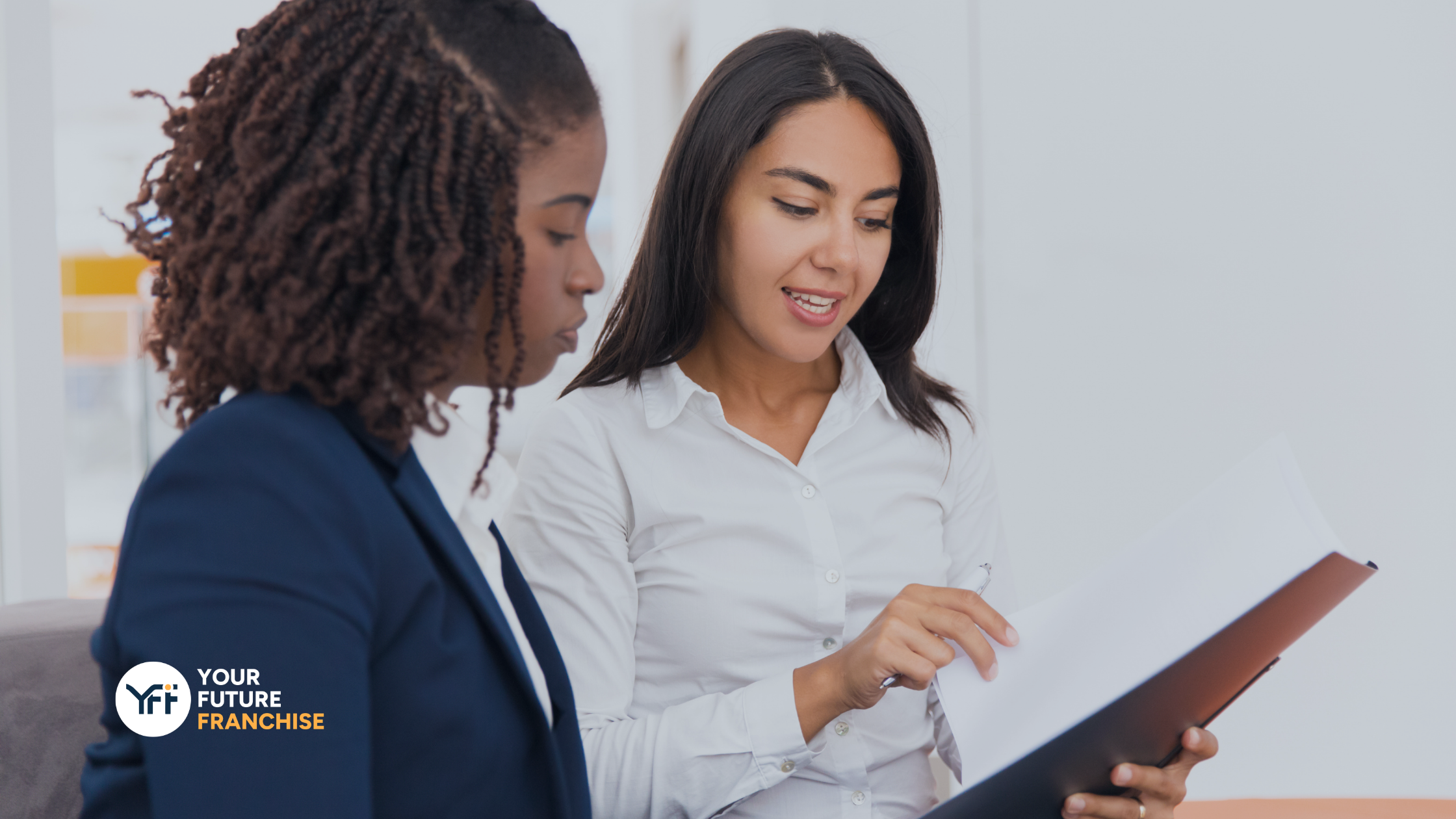 Two women reading a document together