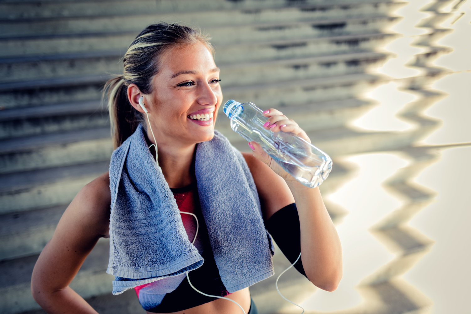 Woman drinking from a clear water bottle.
