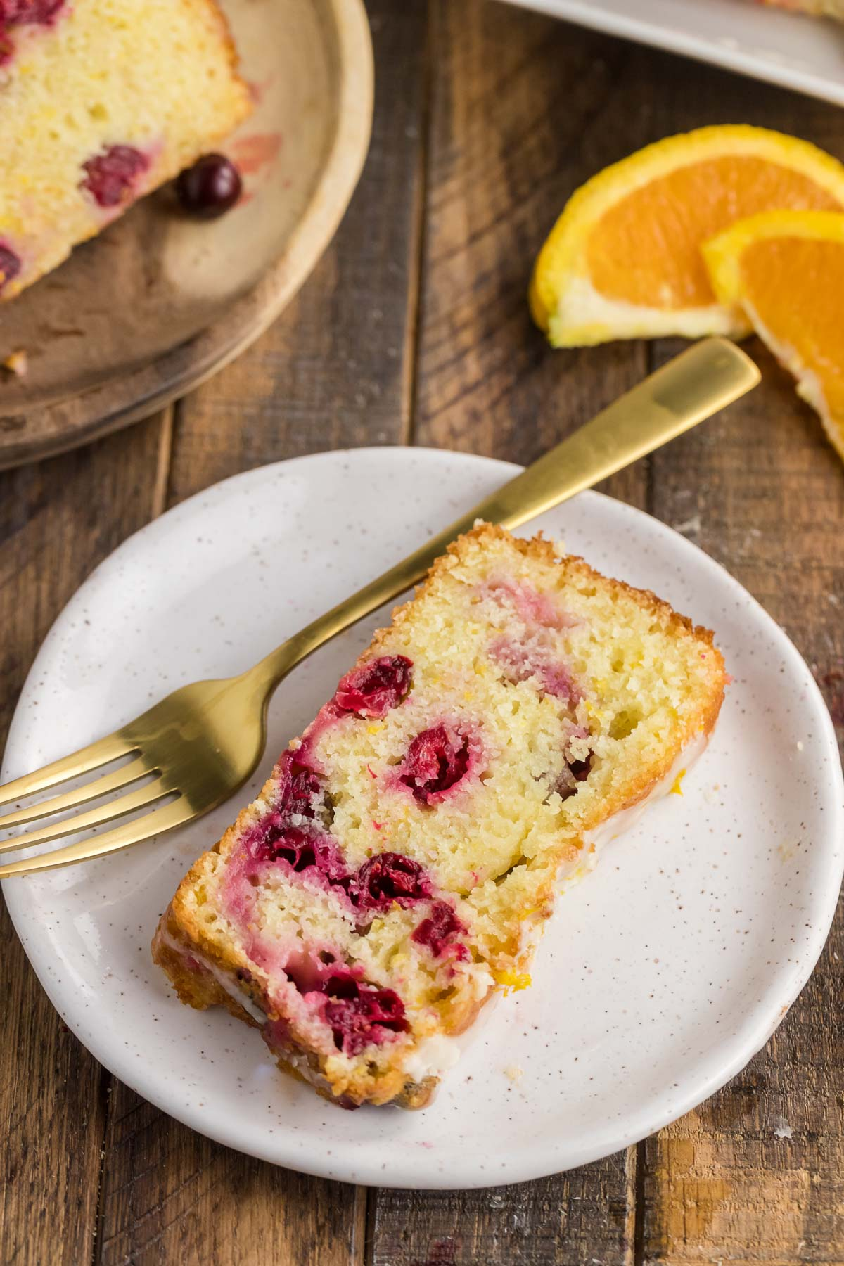 glazed orange cranberry bread on a plate with a fork