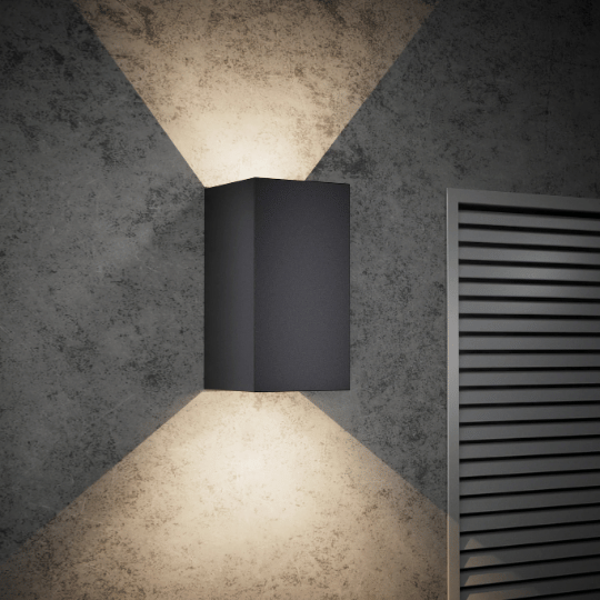 Modern black wall light fixture casting an up-and-down X-shaped beam pattern on a textured grey wall beside a metal vent panel.