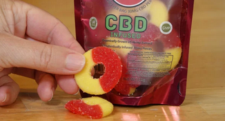 A person holding a bottle of 10mg CBD gummies with a label showing the cannabinoids and phytonutrients found