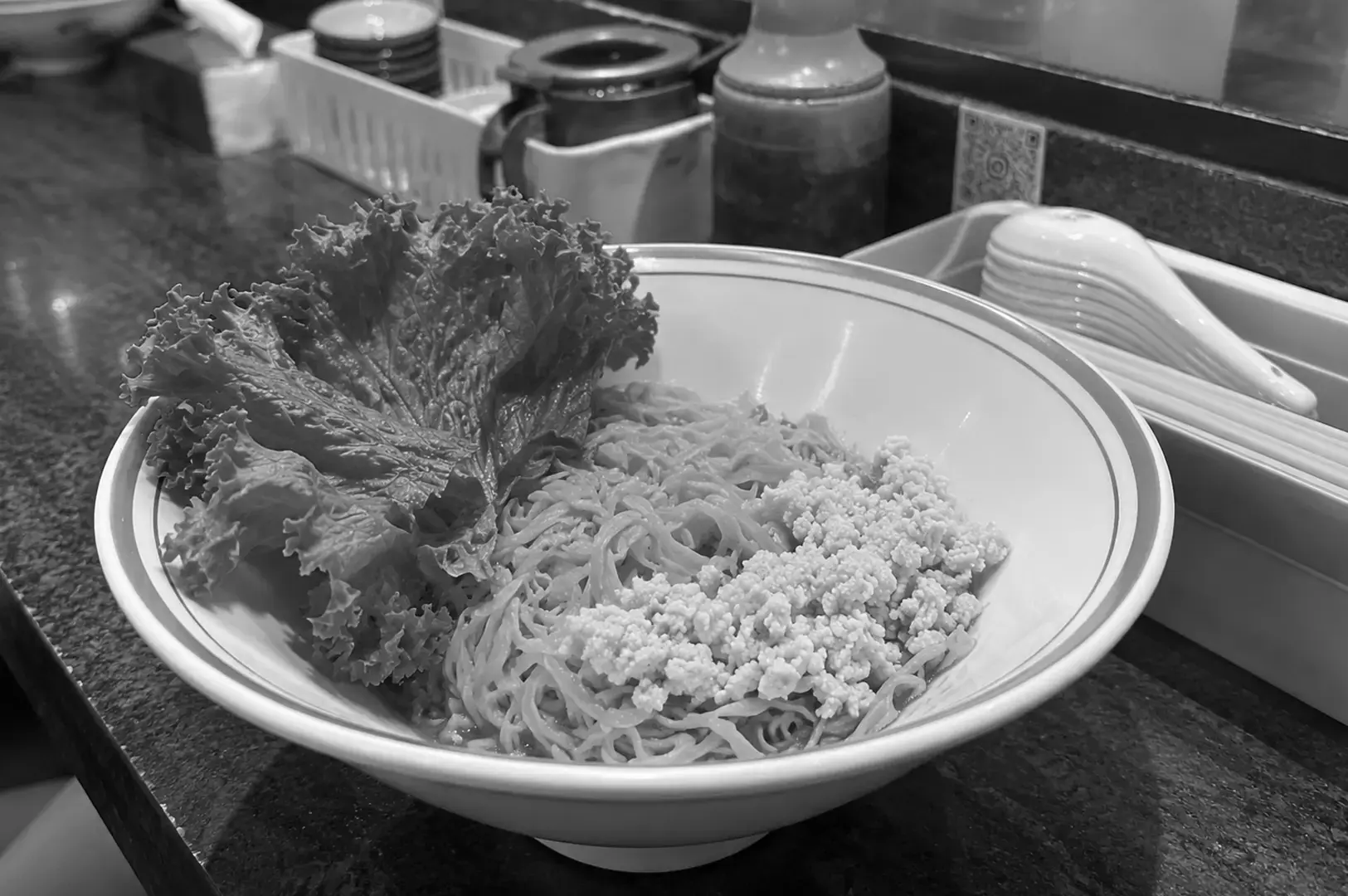 Bak chor mee served with springy noodles, minced pork, sliced meat, and dark, savoury sauce.