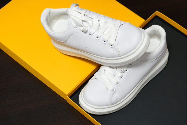 Weiße Sneaker in einem gelben Schuhkarton