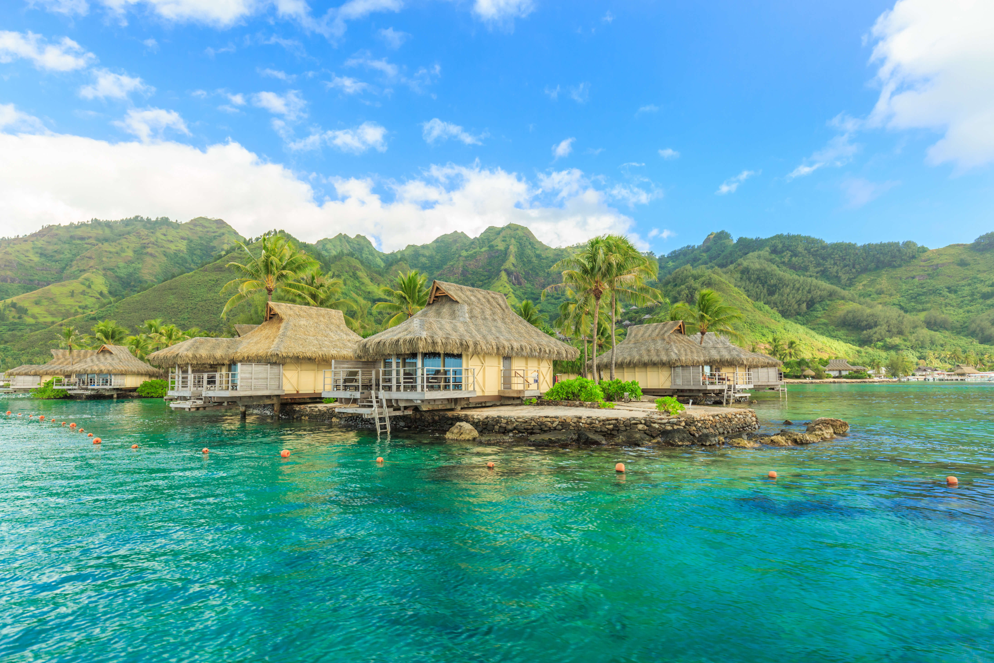 villas next to blue water with mountains in the background