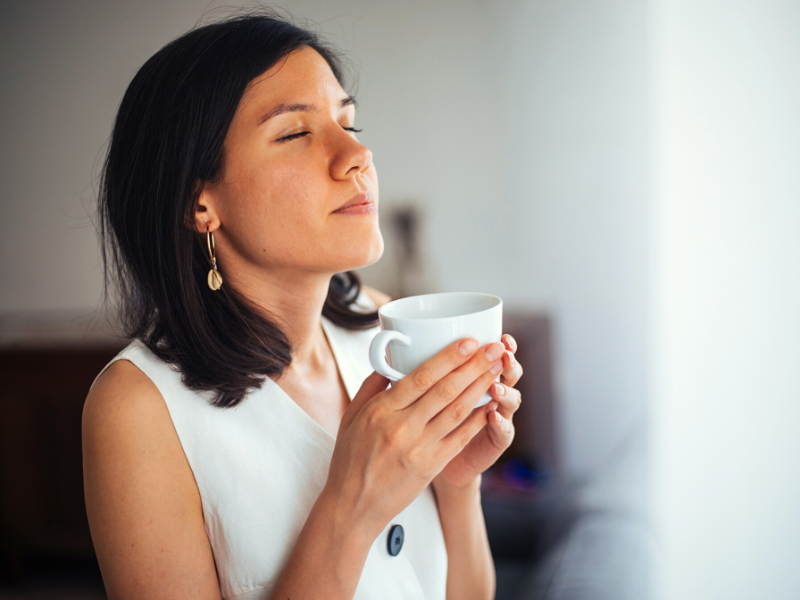 Mulher sentindo o prazer de uma xícara de café. Foto: agrobacter - Canva 