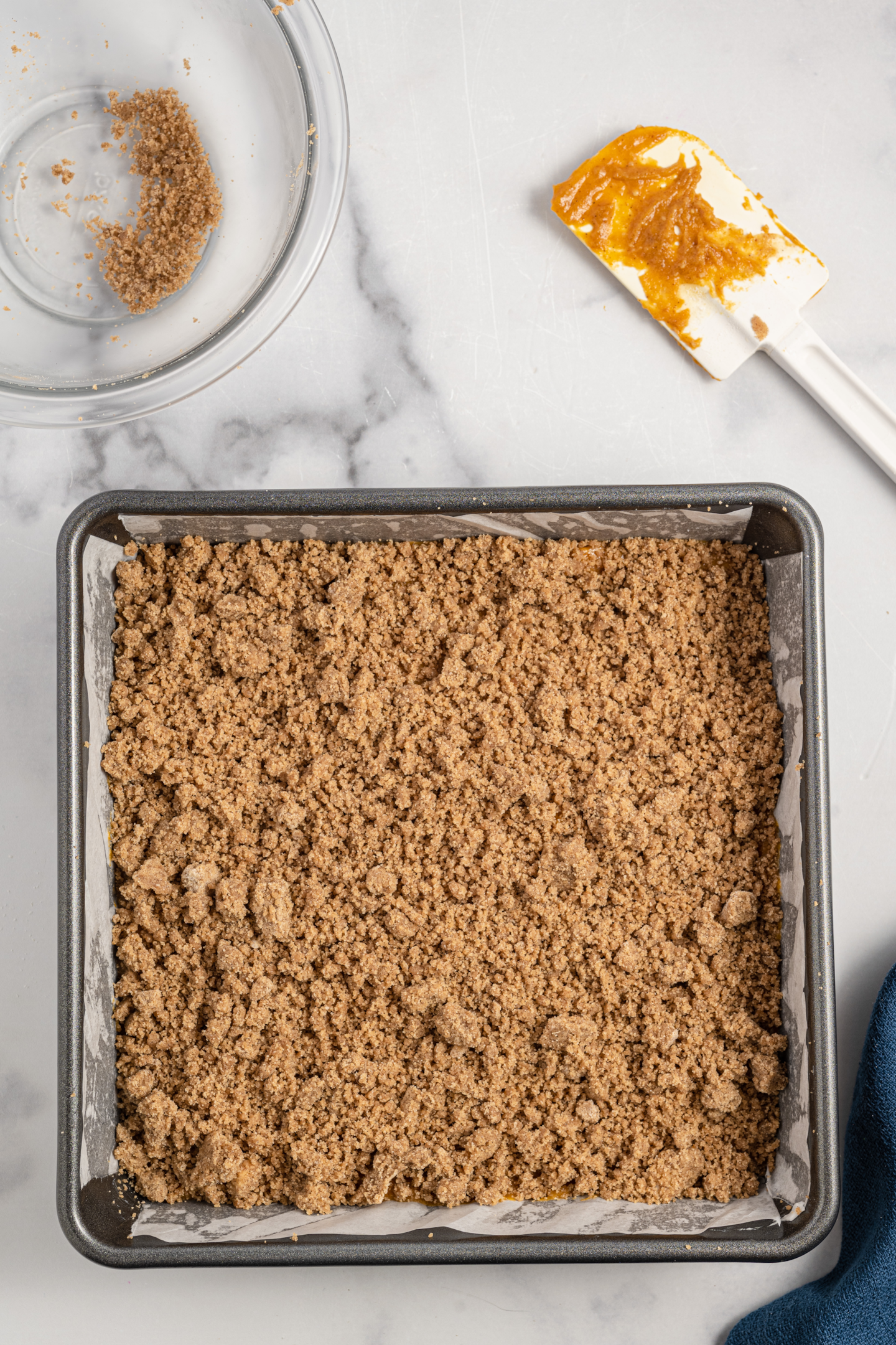 unbaked pumpkin coffee cake in the prepared pan topped with crumb topping