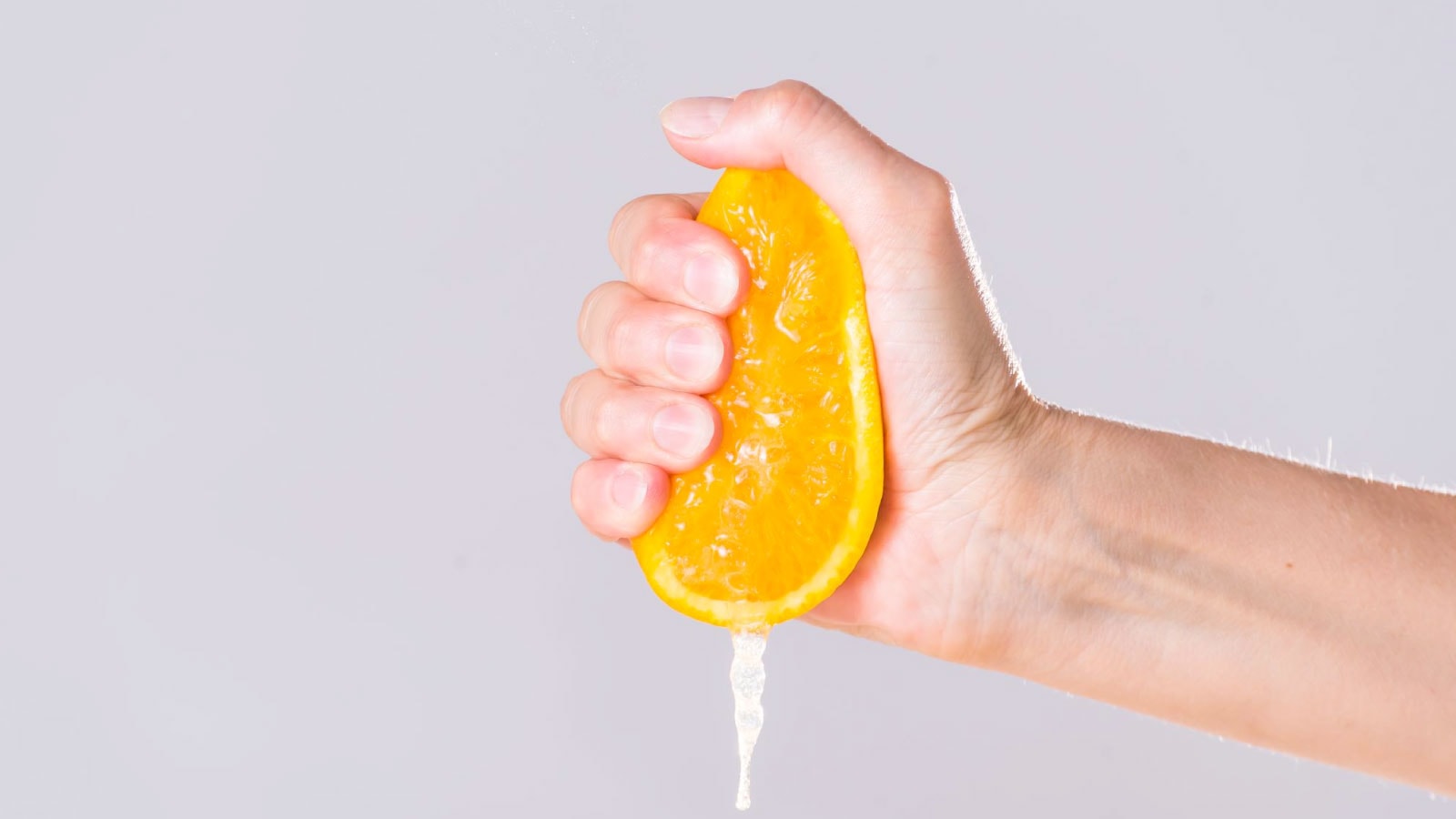 Memeras lemon dengan tangan — bahan alami penghilang noda nikotin di kulit