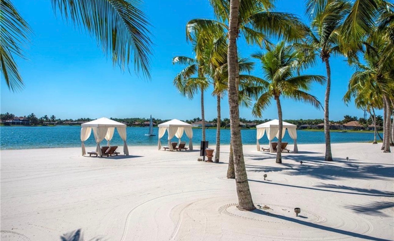 The image depicts a concierge services area where professional staff are assisting residents in a luxury community, showcasing the attentive and personalized service available at Miromar Lakes Beach and Golf Club. This area reflects the vibrant lifestyle and amenities offered, including access to a championship golf course and private white sand beaches.