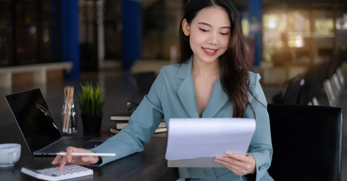 Woman reviewing business income spreadsheet during qbi calculation for OnlyFans taxes planning.