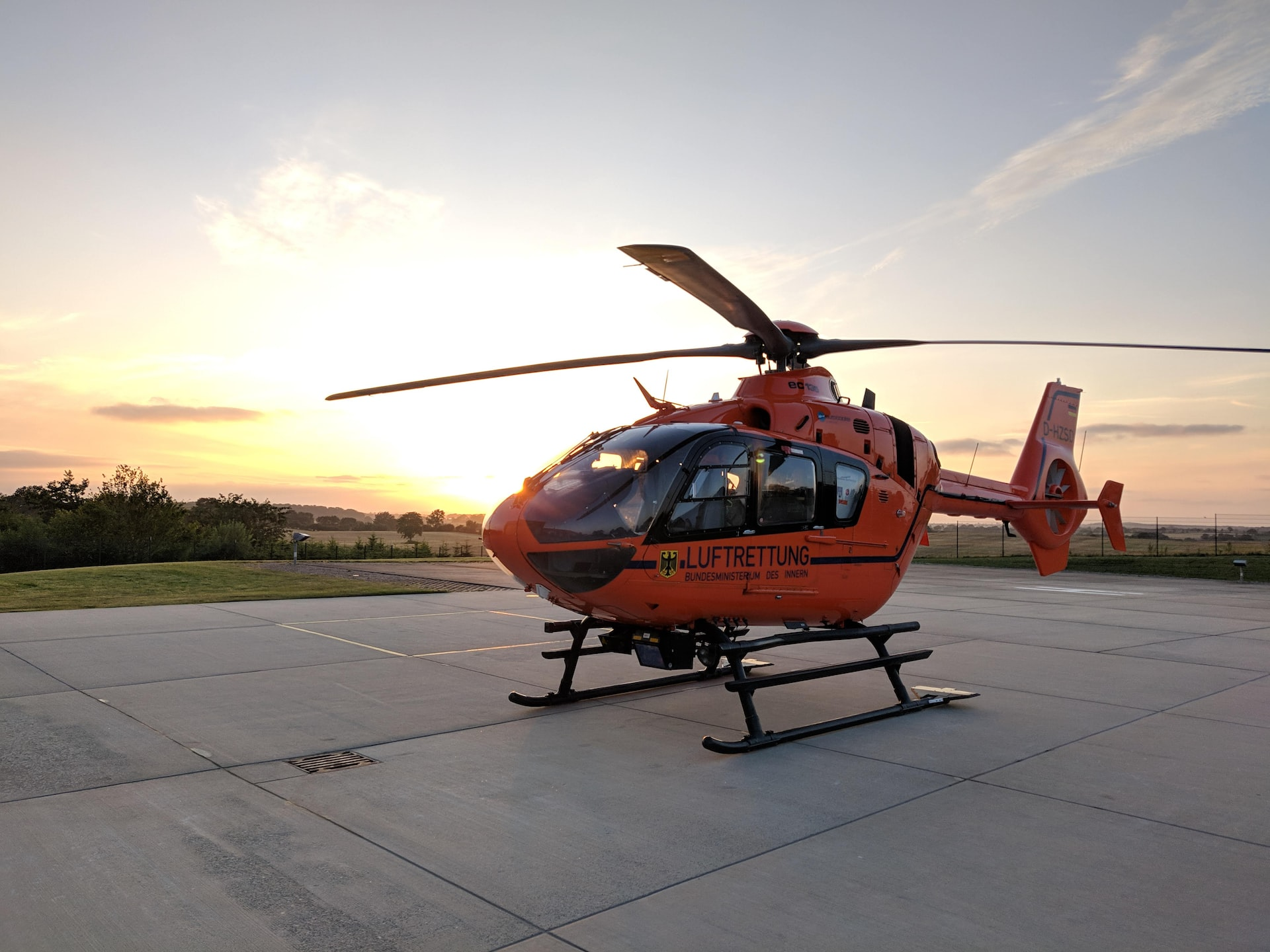An air rescue helicopter stationed on a helipad in sunset.