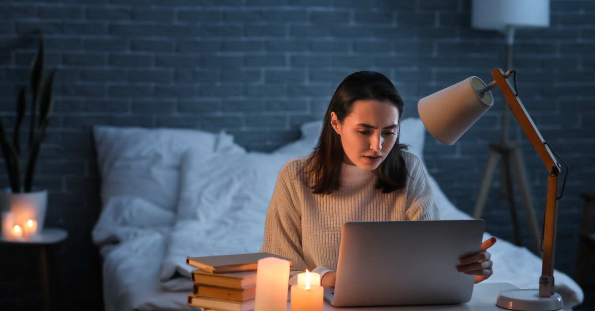 A woman working late on her laptop researching the right principal business code OnlyFans creators should use.