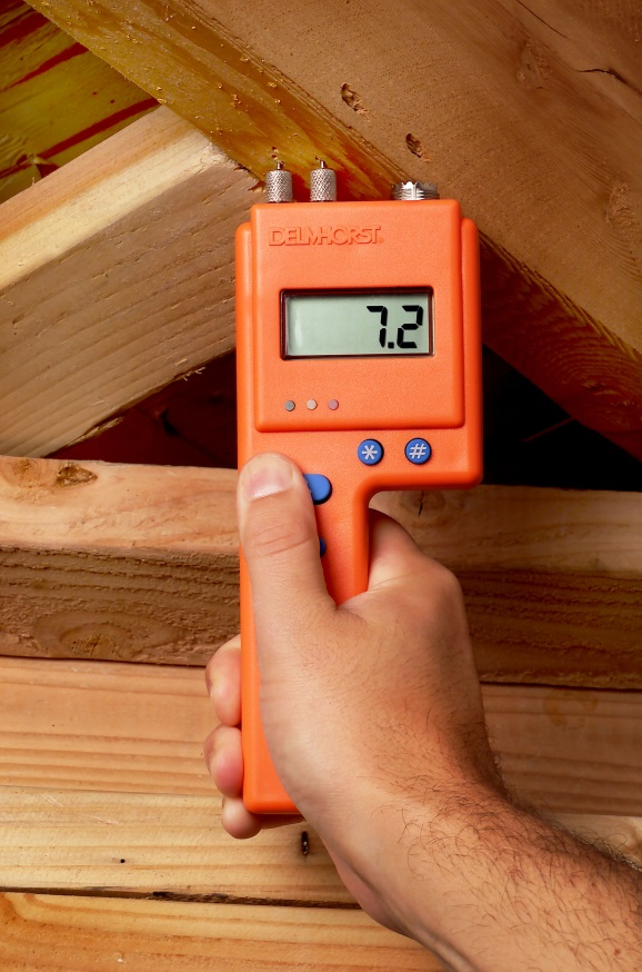 A Delmhorst moisture meter being used to measure the moisture content of wood
