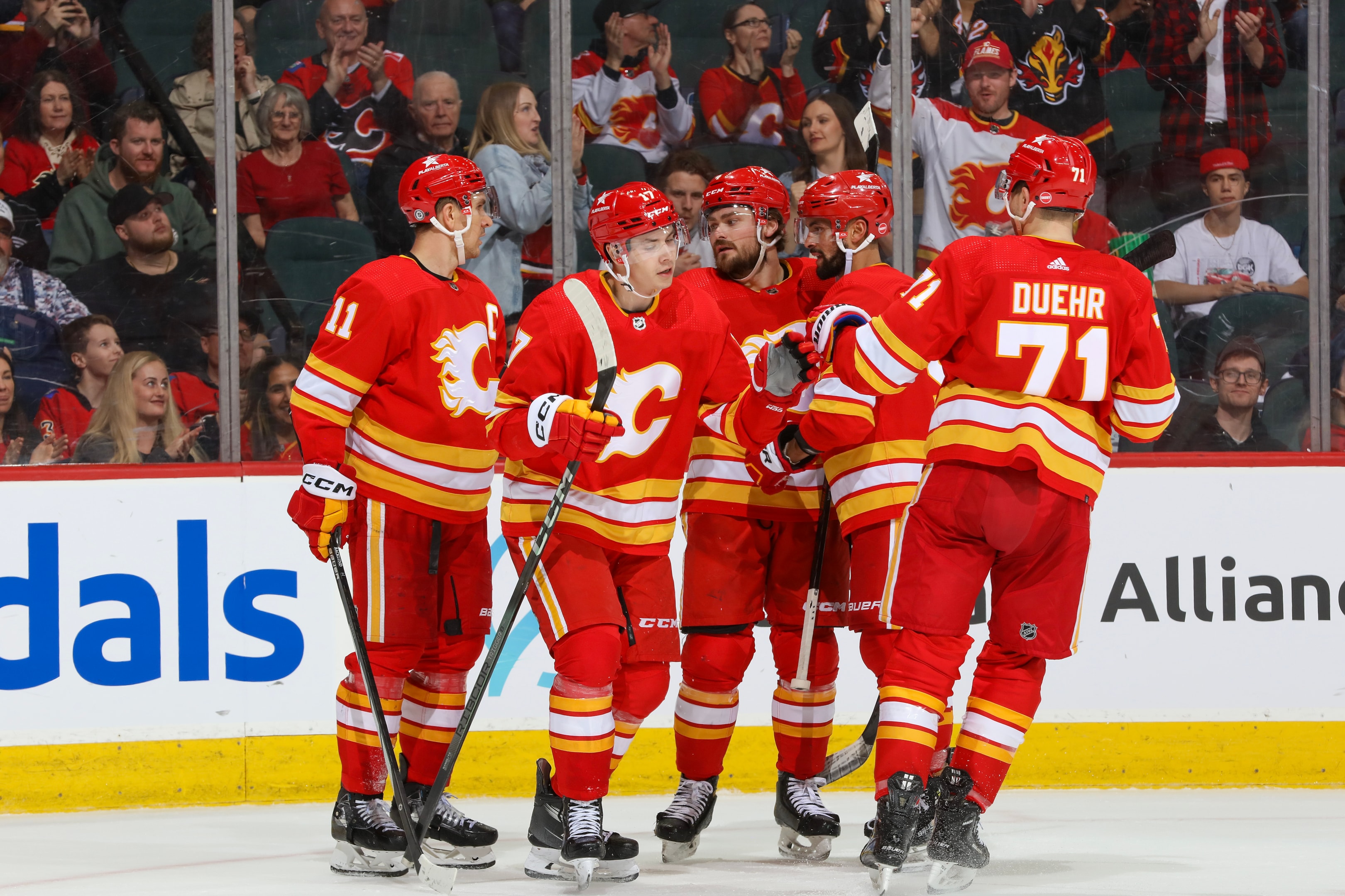 Yegor Sharangovich, Rasmus Andersson and teammates of the Calgary Flames celebrate a goal at the Scotiabank Saddledome on April 14, 2024 in Calgary, Alberta.