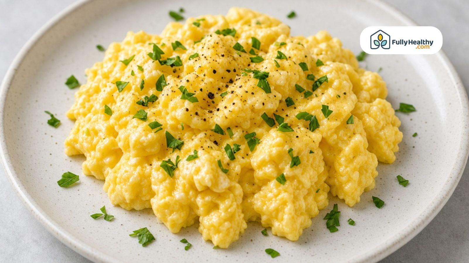 Soft scrambled eggs topped with fresh parsley and black pepper.