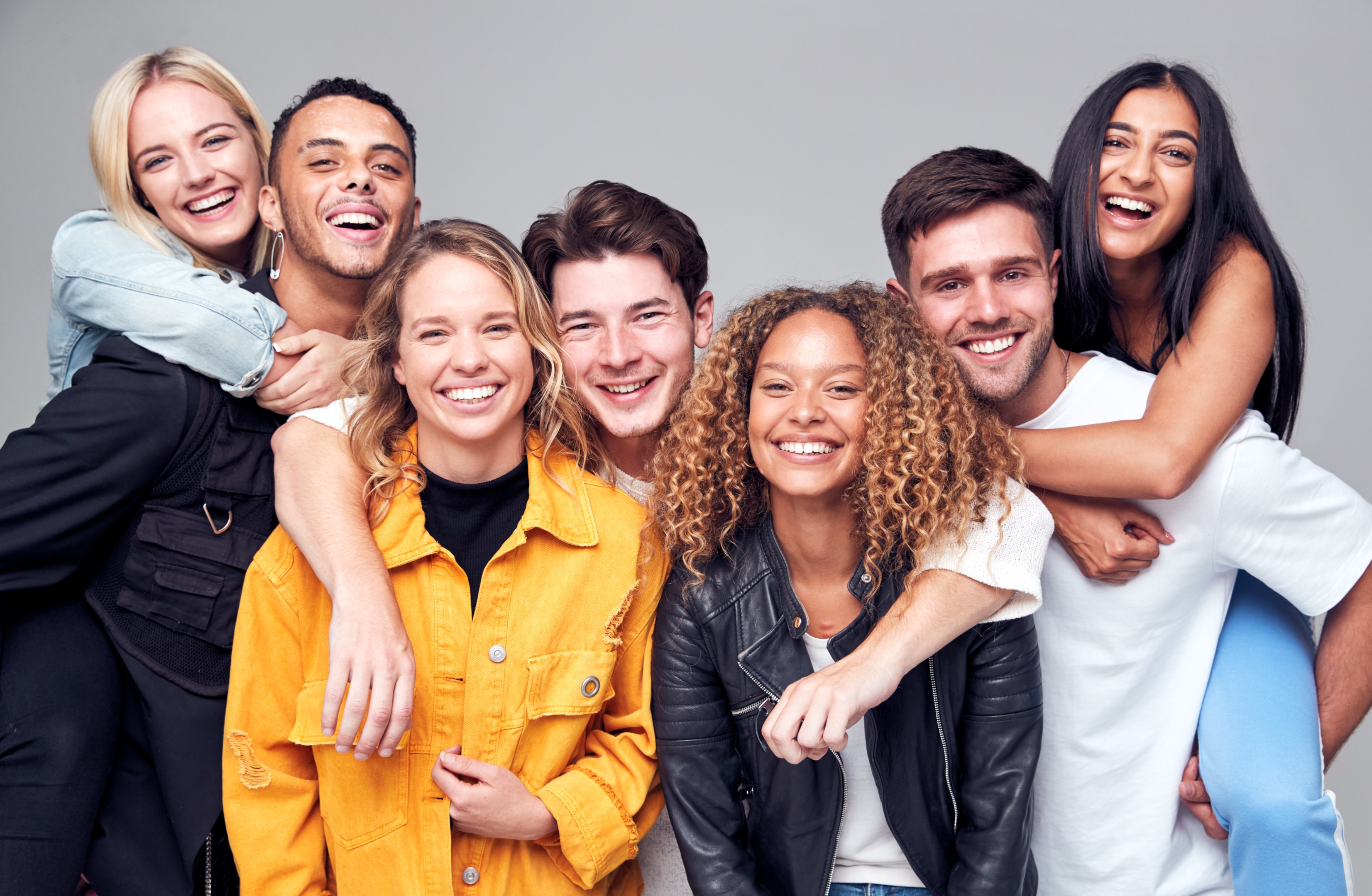 smiling young adults who aren't worriedabout wisdom tooth removal because they had their wisdom teeth removed by Mahogany Oral Surgery's team